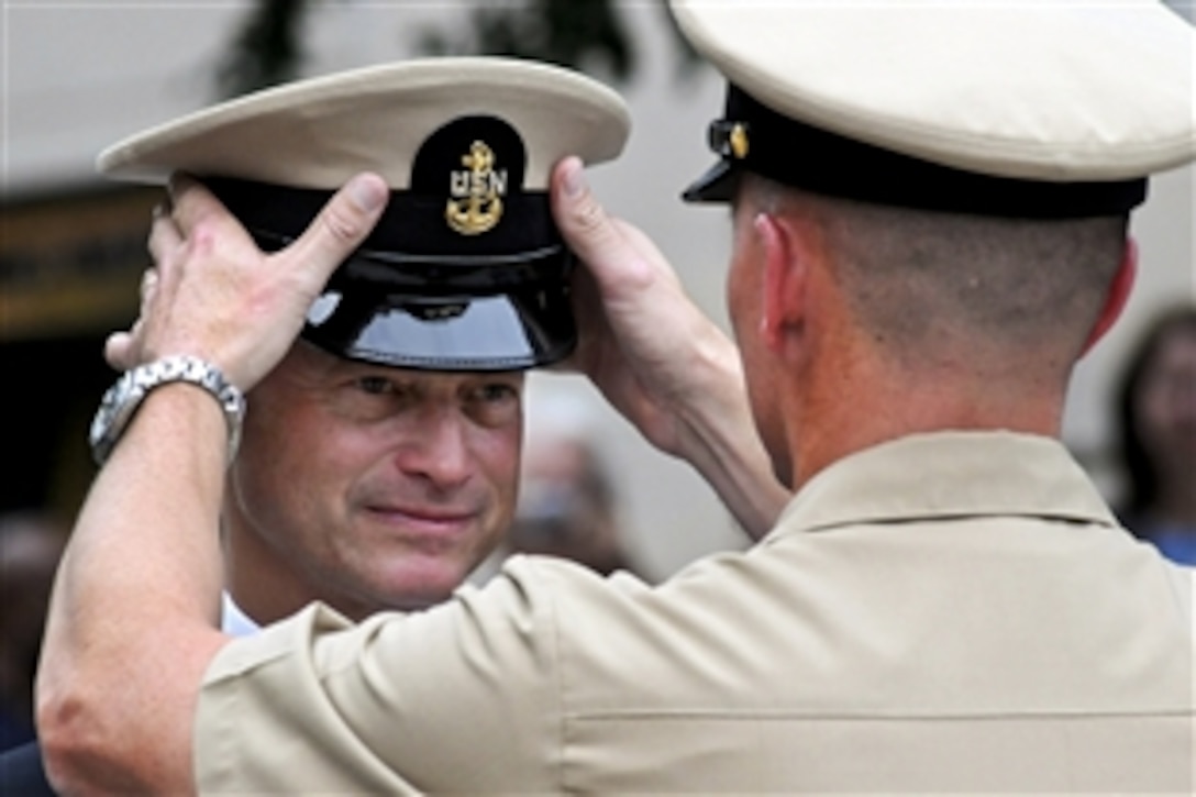 Actor, humanitarian and musician Gary Sinise becomes an honorary chief petty officer during a ceremony at the Navy Memorial and Naval Heritage Center in Washington, D.C., Aug. 24, 2012. Navy Master Chief Petty Officer Michael Stevens, who is slated to become the next Master Chief Petty Officer of the Navy, presented Sinise with his cover.