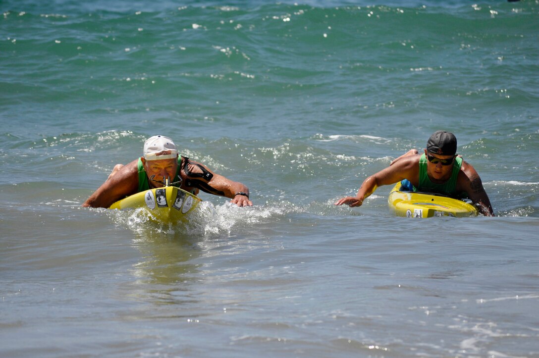 Left to right) Gene Boyer, volunteer with the Jimmy Miller Memorial Foundation, and David McCreary, a platoon sergeant with the Wounded Warrior Battalion-West, paddle to the shore of Manhattan Beach after the 32-mile paddle board race, the Catalina Classic. The WWBn-W was the only relay team to compete in the solo race. 
