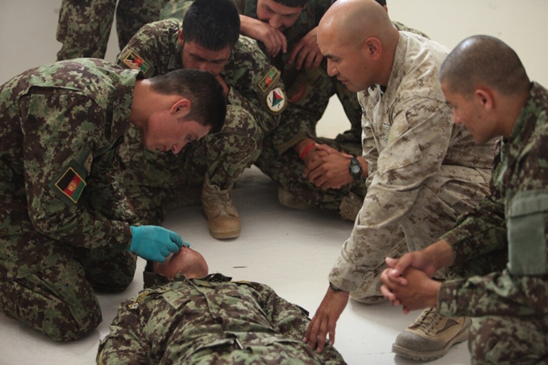 Petty Officer 1st Class Otto Giron, the medical advisor with the Combat Logistics Battalion 5 Embedded Partnering Team, observes a medical course with the 1st Brigade, Afghan National Army at Camp Garmser, Afghanistan, May 30. As part of the EPT, Giron provides guidance to the medical instructors throughout the 8-week long combat life saving course. The soldiers practiced inserting a nasal pharyngeal airway for practical application of the procedure.