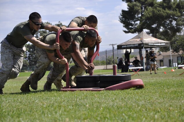 Marines from 1st Light Armored Reconnaissance Battalion’s Bravo Company, Weapons Platoon, also known as the "Awesome" team, pushes a sled weighing more than 180 pounds during the Tactical Athlete Challenge at Camp Pendleton's Paige Fieldhouse, Aug. 28.
