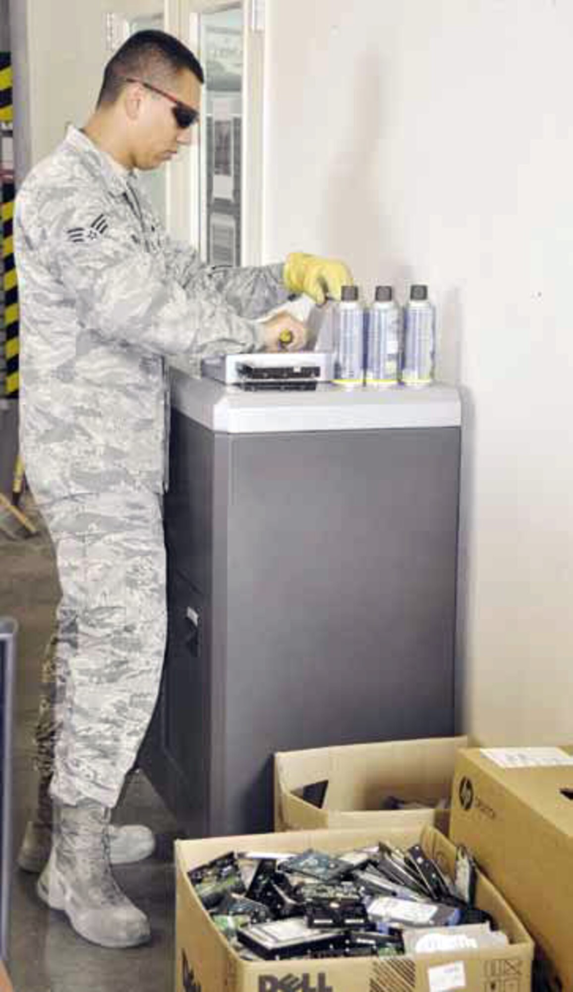 Senior Airman Agustin Tinajero, computer technician, 452nd Communications Squadron, seen here shredding hard drives during the Tech Refresh turn-in, Aug. 23. When computers are turned in, the hard drives are removed and shredded to a unsalvageable state and then scrapped. This process is done to ensure personally identifiable information, or PII, is not inadvertently released when the machines are turned over to DRMO and later sold to government liquidators. (U.S. Air Force photo by Darnell Gardner)