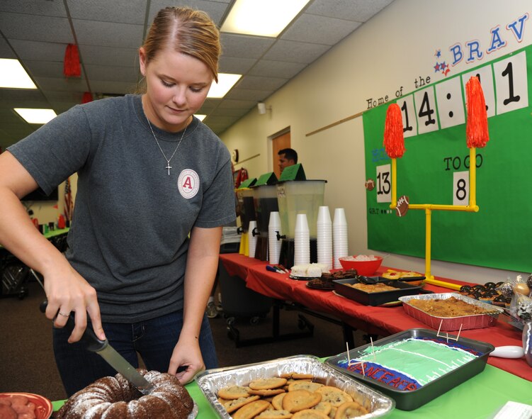 Airman 1st Class Lyndsey Peoples, an air traffic controller with the 71st Operations Support Squadron, cuts a cake during the Singles’ International Gourmet Meal Opportunity Aug. 27 in the Community Chapel Activity Center at Vance Air Force Base, Okla. (U.S. Air Force photo/ Airman 1st Class Frank Casciotta)
