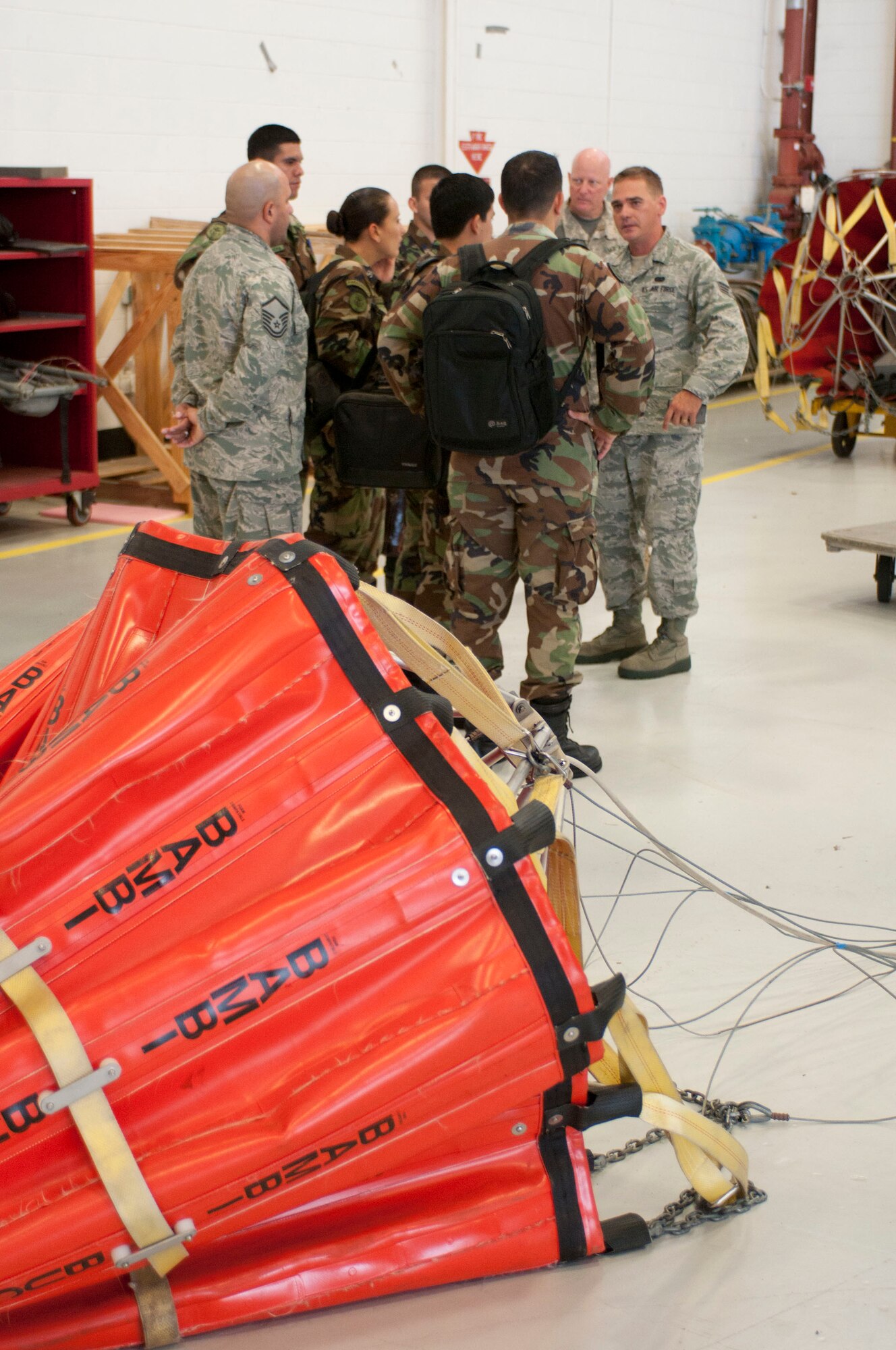 Massachusetts Air National Guard Senior Airman Luiz Vicentini (right) translates information about the "Bambi Bucket" system into Spanish as he talks with Paraguayan air force helicopter pilots, who also use a similar aerial water delivery system, Aug. 28, 2012, on the Massachusetts Military Reservation. Five Paraguayan air force pilots were in Massachusetts as part of the National Guard State Partnership Program, a 20-year-old program that partners states with countries around the world to facilitate cooperation across all aspects of civilian-military affairs and encourages people-to-people ties at the state level. (Air National Guard photo by Master Sgt. Aaron Smith/Released)