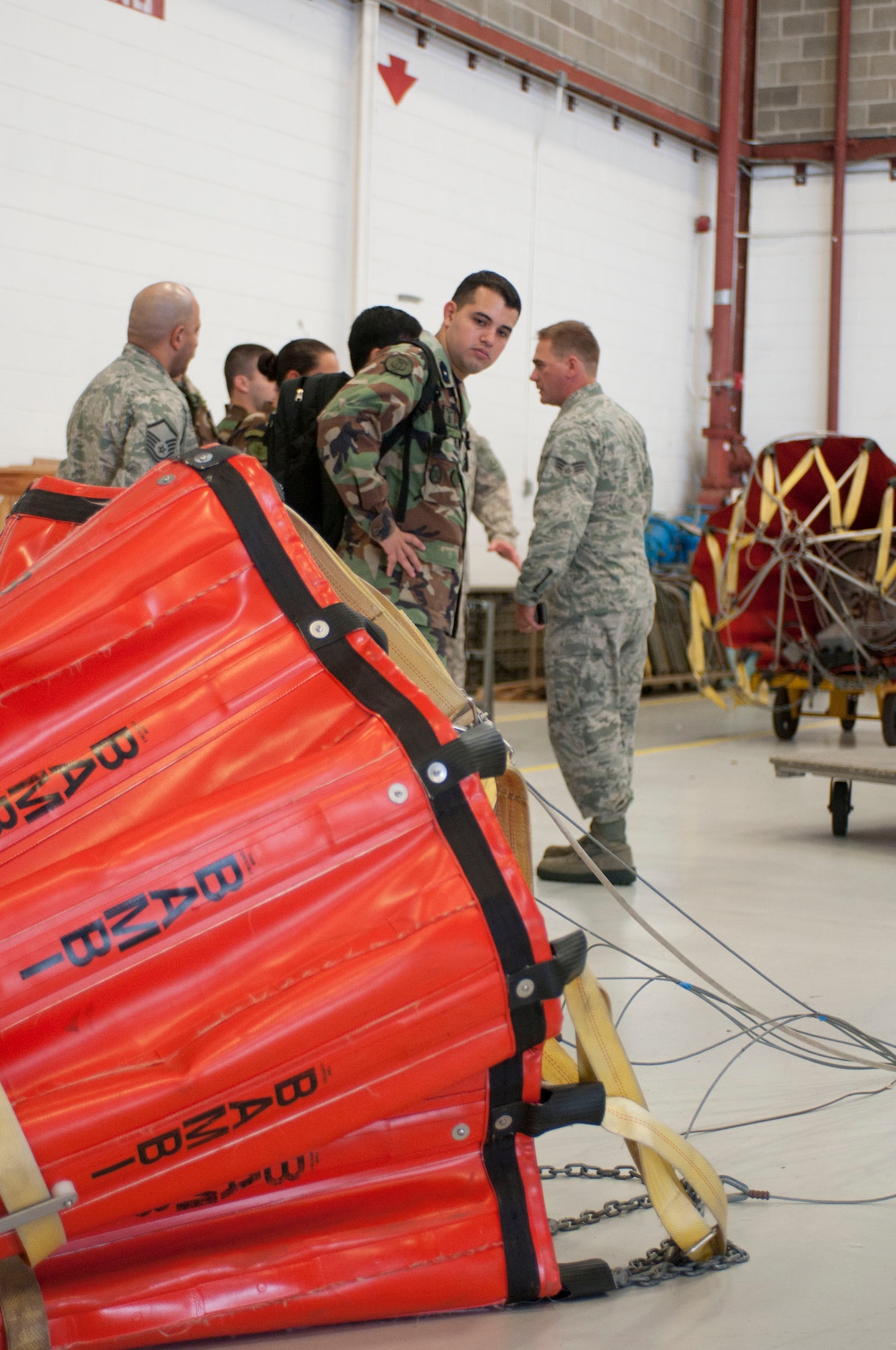 Massachusetts Air National Guard Senior Airman Luiz Vicentini (right) translates information about the "Bambi Bucket" system into Spanish as he speaks with Paraguayan air force helicopter pilots, who also use a similar aerial water delivery system, Aug. 28, 2012, on the Massachusetts Military Reservation. Five Paraguayan air force pilots were in Massachusetts as part of the National Guard State Partnership Program, a 20-year-old program that partners states with countries around the world to facilitate cooperation across all aspects of civilian-military affairs and encourage people-to-people ties at the state level. (Air National Guard photo by Master Sgt. Aaron Smith/Released)