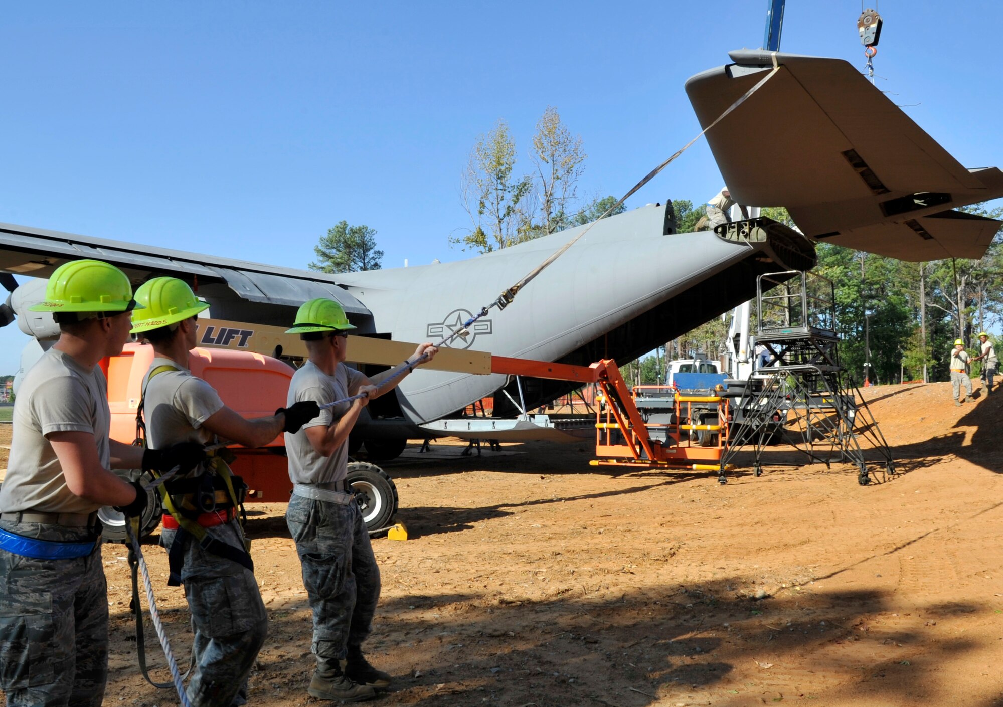 Members of the 19th Equipment Maintenance Squadron pull a horizontal tail piece for a C-130E into place Aug. 29, 2012, in Jacksonville, Ark. 19th Squadrons work together to complete the static display in front of the Little Rock Air Force Base - City of Jacksonville Joint Education Center. (U.S. Air Force photo by Staff Sgt. Caleb Pierce)
