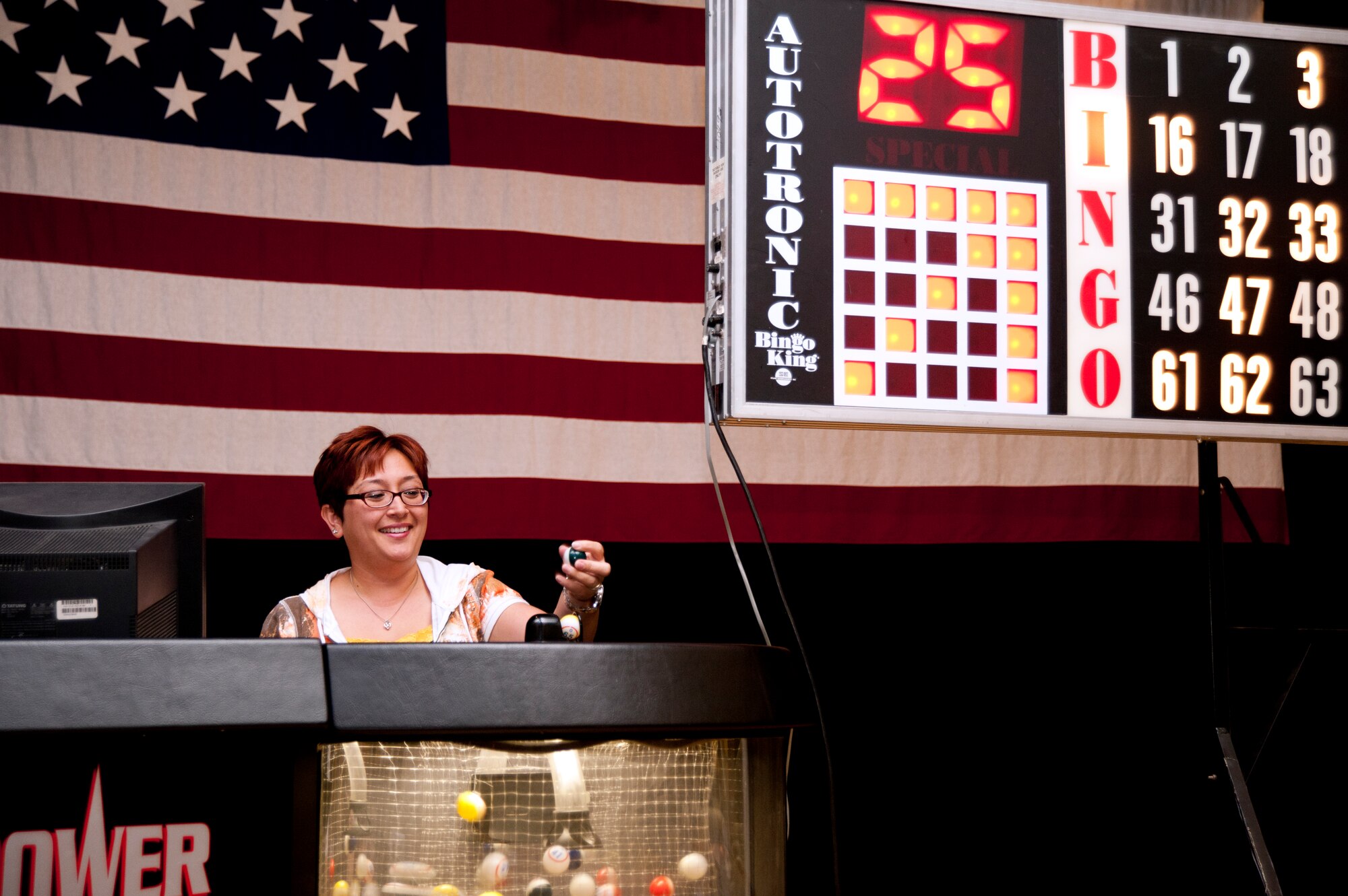 Fe Vorderlandwehr, 22nd Force Support Squadron community center director, calls out a number during a game of bingo in the Robert J. Dole Community Center Ballroom August 21, 2012. Bingo is just one of the many programs and events Vorderlandwehr oversees for the community center on base. (U.S. Air Force photo/Airman 1st Class Victor J. Caputo)