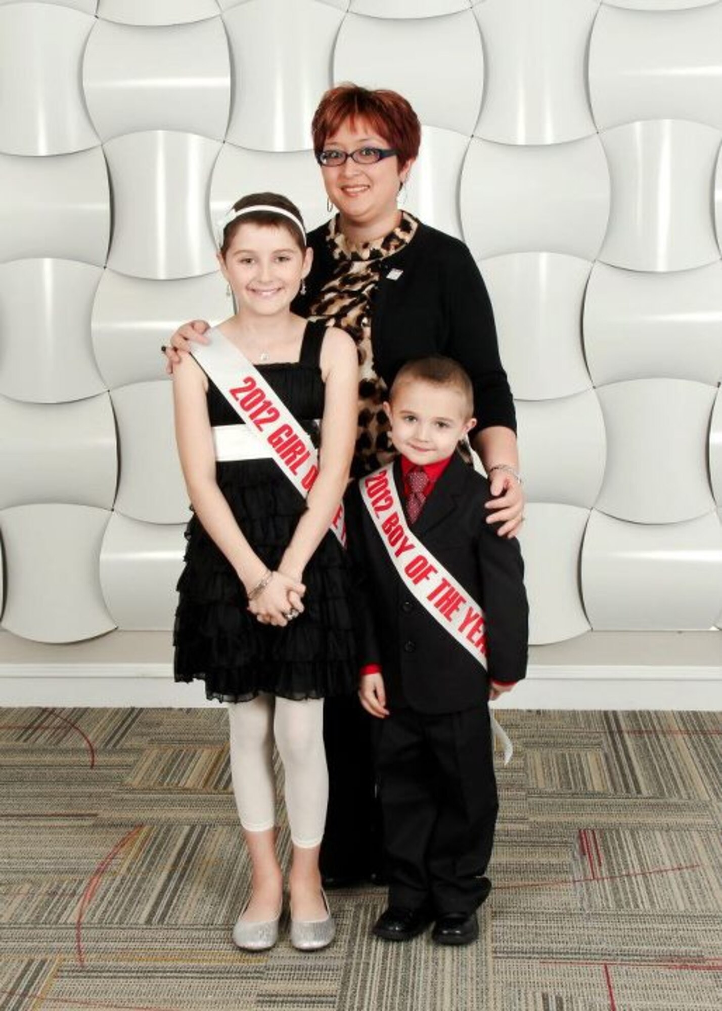 Fe Vorderlandwehr, 22nd Force Support Squadron community center director, and Leukemia and Lymphoma Society 2012 Woman of the Year, poses with the Girl and Boy of the Year, Mikala and Joey. Vorderlandwehr and her group managed to raise over $58,000 towards the LLS cause. (Courtesy photo)