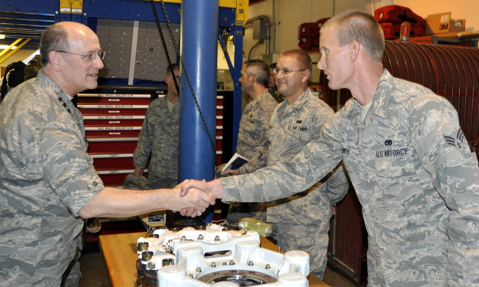 Lt. Gen. James F. Jackson, chief of Air Force Reserve, and commander, Air Force Reserve Command shakes the hand of Senior Airman Collin Smith of the 302nd Maintenance Squadron hydraulics shop during the general’s visit of the 302nd Airlift Wing at Peterson Air Force Base, Colo. During the Aug. 28, 2012 visit, Smith explained to Jackson how the 302nd Maintenance Squadron began using Time Compliance Technical Order 2098, a new carbon brake system that can perform 850 percent more landings than the previous system. It is expected to save the Air Force $327 million when installations are complete. (U.S Air Force photo/Tech. Sgt. Daniel Butterfield)