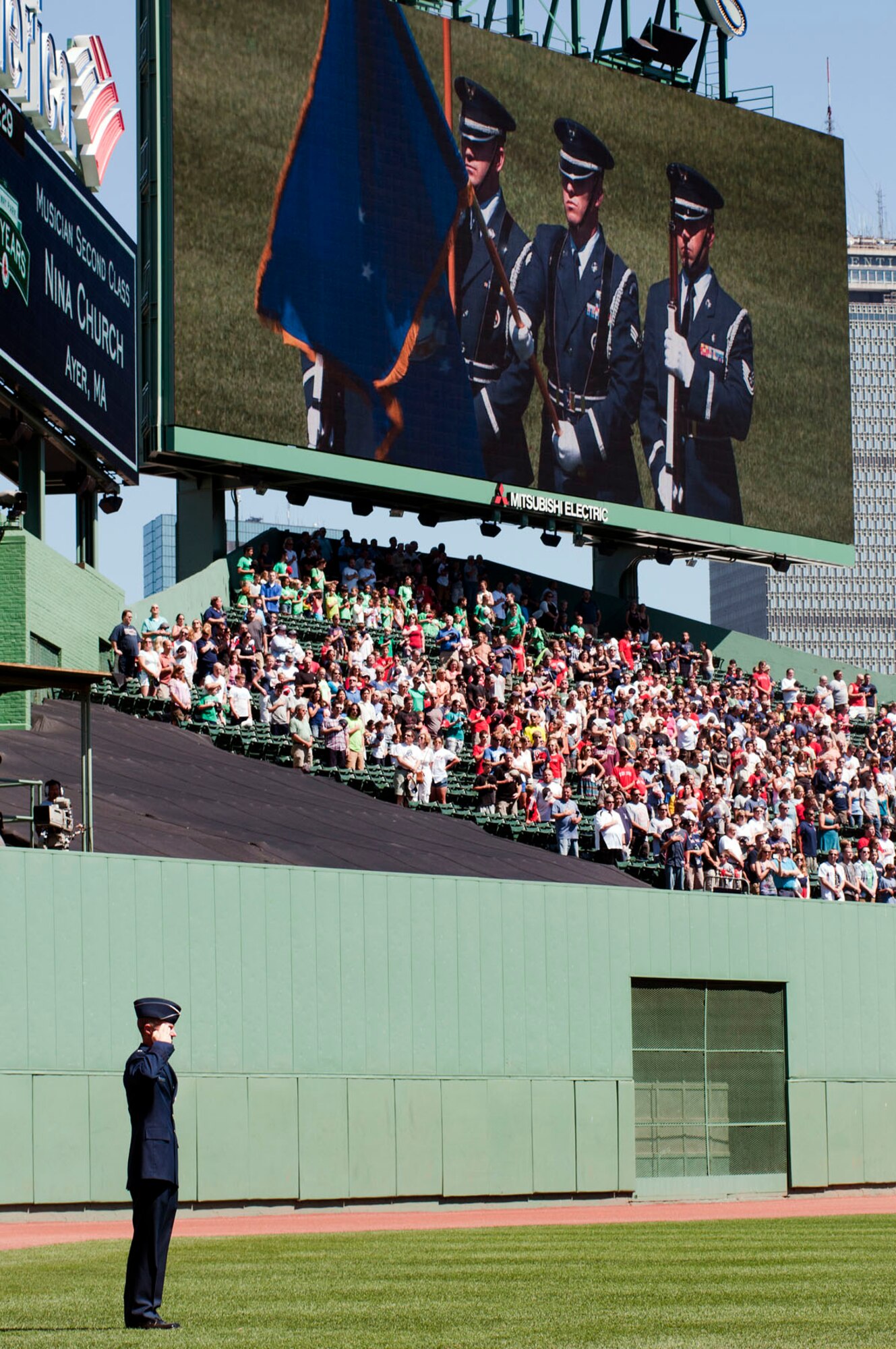 BOSTON -- Maj. Gen. Craig Olson, C3I and Networks program executive officer, salutes during the national anthem as an honor guard detail from Hanscom appears on a centerfield display before a Red Sox game at Fenway Park Aug. 27. Members of the U.S. armed forces were invited to the game as part of the organization’s Tickets for Troops program. (U.S. Air Force photo by Mark Wyatt)