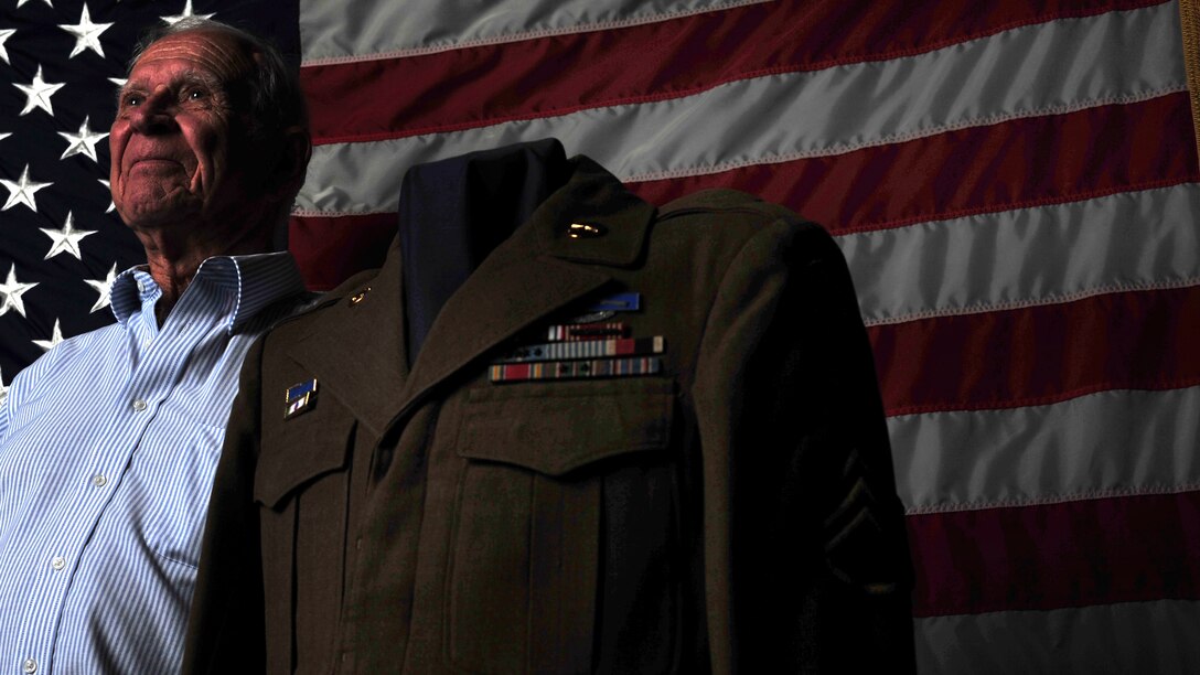 Clovis, N.M., veteran Dan McKinney, stands next to his old uniform at Cannon Air Force Base, N.M., Aug. 16, 2012. McKinney served as a prisoner of war in the Korean War and has shared his experience with 50 Airman Leadership School classes in order that they might understand the sacrifices made so they can live in peace. (U.S. Air Force photo/Airman 1st Class Ericka Engblom)