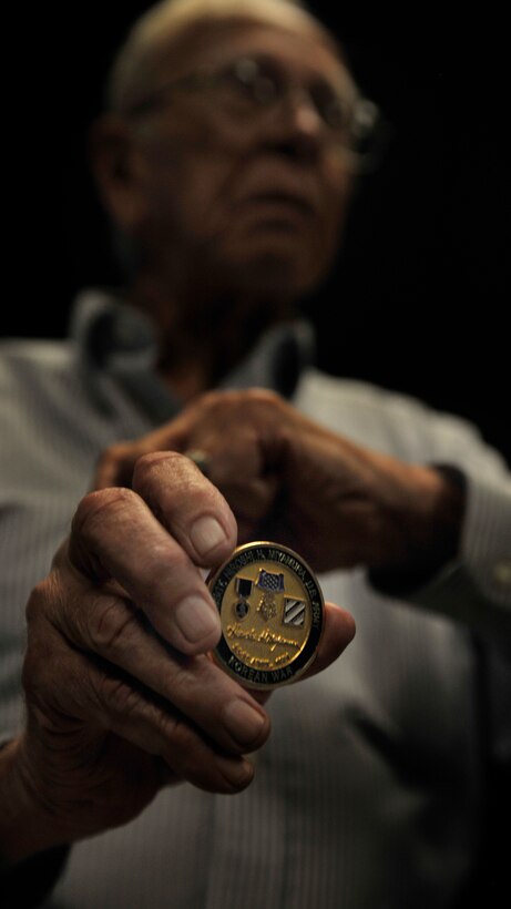 Clovis, N.M., veteran Dan McKinney, holds a coin awarded to him by the President of the United States for his dedication to his country at Cannon Air Force Base, N.M., Aug. 16, 2012. McKinney served as a prisoner of war in the Korean War and has shared his experience with 50 Airman Leadership School classes in order that they might understand the sacrifices made so they can live in peace. (U.S. Air Force photo/Airman 1st Class Ericka Engblom)