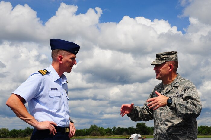 Commander Brian LeFebvre, United States Coast Guard Sector Charleston response chief, speaks with Col. Richard McComb, Joint Base Charleston commander, Aug. 22, 2012, on the U.S. Coast Guard Cutter Yellowfin at Joint Base Charleston – Weapons Station, S.C. during a visit….etc. (need to know why he is there)(U.S. Air Force photo/ Airman 1st Class Chacarra Walker)