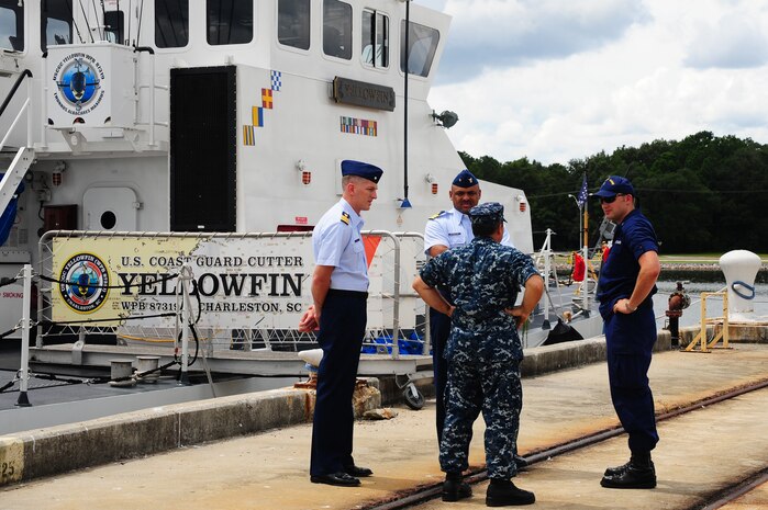 Lieutenant junior grade Andy Daum (right), Coast Guard Cutter Yellowfin commanding officer, Cmdr. Brian LeFebvre (center), U.S. Coast Guard Sector Charleston response chief, Chief Warrant Officer 3 John Wilson, 628 Logistics Readiness Squadron Port Operations officer and Cmdr. Jason Merriweather, USCG Sector Charleston deputy commander, make preparations before the South Carolina Military Task Force arrival Aug. 22, 2012 at Joint Base Charleston - Weapons Station, S.C. The S.C. Military Base Task Force’s purpose is to enhance the value of military installations and facilities and the quality of life for military personnel located in South Carolina. (U.S. Air Force photo/ Airman 1st Class Chacarra Walker)