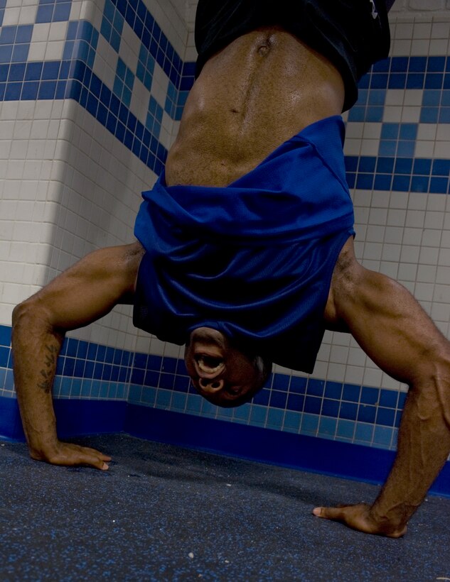 U.S. Air Force Master Sgt. Lafonza Spencer, Air Combat Command manpower management analyst, performs hand-stand pushups inside the Warrior Zone at Langley Air Force Base, Va., Aug. 19, 2012.  Spencer visits the Warrior Zone, inside the Air Combat Command Fitness Center, several times throughout the week as part of his workout routine.  (U.S. Air Force photo by Senior Airman Stephanie Rubi / Released)