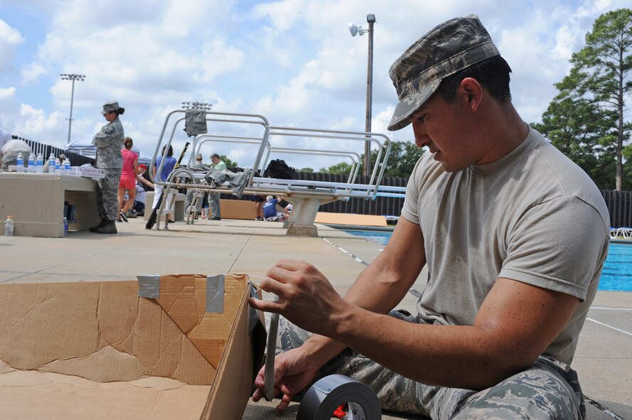 U.S. Air Force Capt. Nicki Morales, 4th Logistics Readiness Squadron compliance officer, applies tape to a cardboard boat during a build-a-boat competition on Seymour Johnson Air Force Base, N.C., Aug. 22, 2012. Teams were given one hour to construct a boat out of cardboard and duct tape to be given an opportunity to race across the Olympic pool to win prizes. (U.S. Air Force photo/Airman 1st Class John Nieves Camacho/Released)