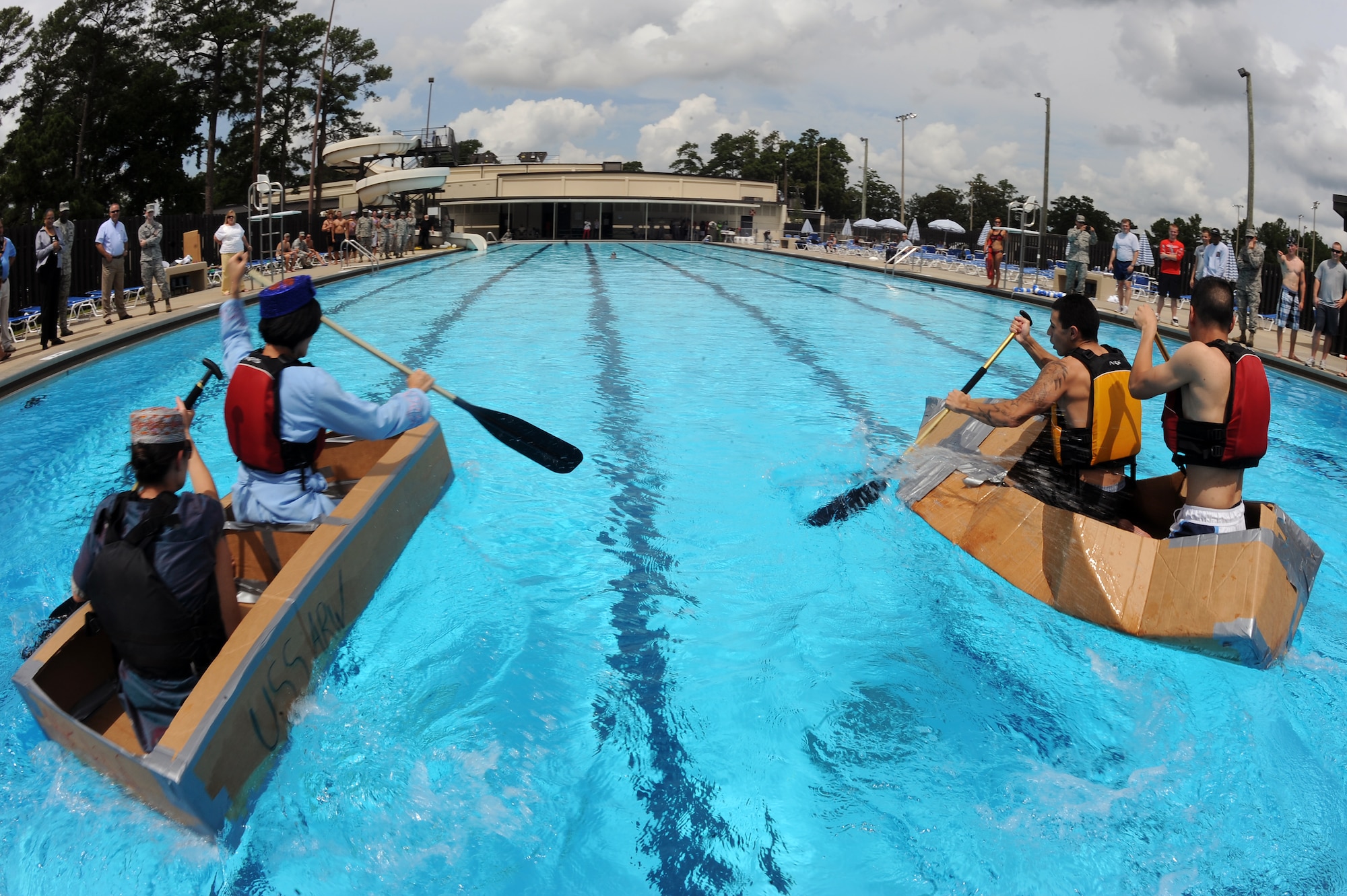 Airmen competing in a build-a-boat contest race across the Olympic pool on Seymour Johnson Air Force Base, N.C., Aug. 22, 2012. Teams raced the clock and each other, paddling 50 meters to the finish line to win the competition. (U.S. Air Force photo/Airman 1st Class John Nieves Camacho/Released)