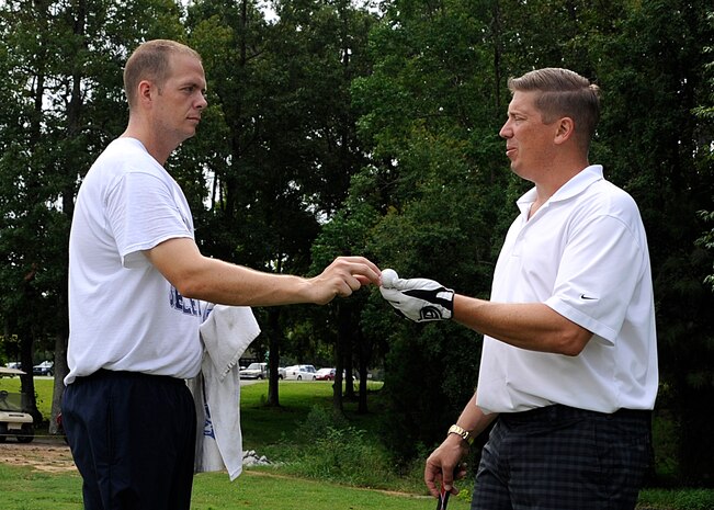 Chief Petty Officer Selectee Jeremy Price, Naval Consolidated Brig Charleston, Bravo Unit 1 Manager, ensures Senior Chief Petty Officer Kelly Richardson, Navy Health Clinic Charleston command senior chief, gets his golf ball back during the Chief Petty Officer Selectee golf tournament Aug. 24, 2012, at Joint Base Charleston-Weapons Station. The chief selectees serve as caddies for the chief petty officers, enabling the selectees to meet and interact with their future Chief’s Mess. (U.S. Air Force photo/Staff Sgt. Rasheen Douglas)