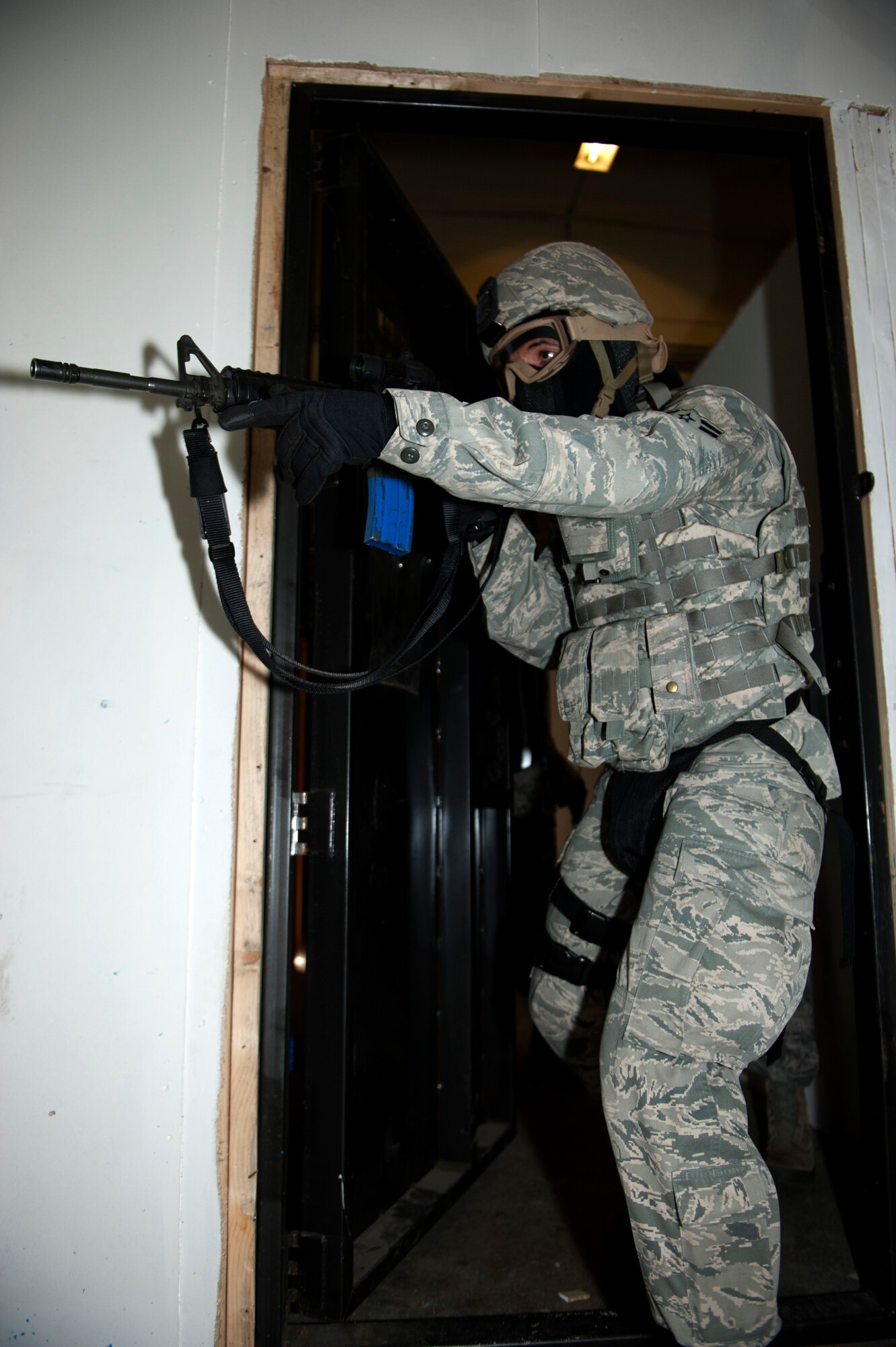 SPANGDAHLEM AIR BASE, Germany – Airman 1st Class Joseph Guy, 52nd Security Forces Squadron entry controller, searches a building for hostile forces during an active-shooter exercise inside a training warehouse here Aug. 28.  In this active-shooter training, 52nd SFS Airmen must enter a house under control of hostile forces and eliminate the threat while identifying and controlling non-hostile inhabitants.  Security forces Airmen put their skills and knowledge to the test in simulated hostile environments to prepare for real-world events. (U.S. Air Force photo by Airman 1st Class Gustavo Castillo/Released)
