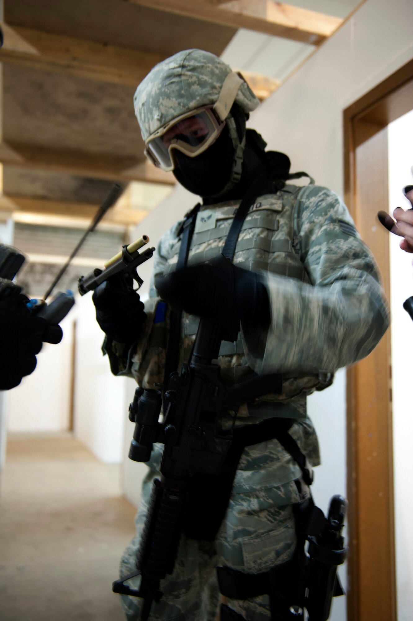 SPANGDAHLEM AIR BASE, Germany – Senior Airman Brian Allio, 52nd Security Forces Squadron patrolman, clears his training pistol of ammunition during an active-shooter exercise inside a training warehouse here Aug. 28.  In this active-shooter training, 52nd SFS Airmen must enter a house under control of hostile forces and eliminate the threat while identifying and controlling non-hostile inhabitants.  Security forces Airmen put their skills and knowledge to the test in simulated hostile environments to prepare for real-world events. (U.S. Air Force photo by Airman 1st Class Gustavo Castillo/Released)