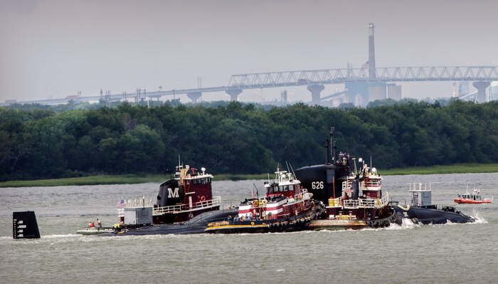 Harbor tugs guide Moored Training Ship 626 - Daniel Webster SSBN 626 up the Cooper River towards Joint Base Charleston – Weapons Station, Aug. 25, 2012, at Charleston, S.C. An ocean-going tug towed the Moored Training Ship from Portsmouth, Va. to JB Charleston – Weapons Station following a scheduled dry-dock maintenance period at Norfolk Naval Shipyard, Norfolk, Va. The ship returned to JB Charleston – Weapons Station to resume its training mission. (U.S. Air Force photo / Airman 1st Class Tom Brading)