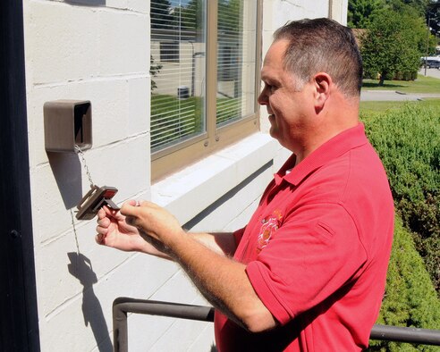 HANSCOM AIR FORCE BASE, Mass. - Paul Seguin, Hanscom Fire Department assistant chief of operations, performs an inspection on the Knox-Box outside Building 1508. The Knox-Box is a secure, rapid entrance program specifically controlled by the fire department. With one master key, the fire department can gain access to any building on base, which reduces response time and property damage in the event of an emergency. (U.S. Air Force photo by Linda LaBonte Britt)