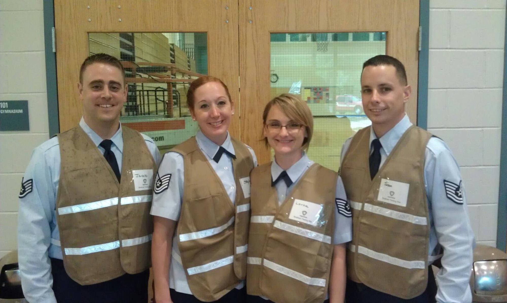 STRATHAM, N.H. – (left to right) Staff Sgt. Jacob Bender, Tech. Sgt. Stephanie Satinsky, Tech. Sgt. Lorna Allen and Tech. Sgt. Jason Maloney, health profession recruiters for the 360th Recruiting Group, E Flight, in Burlington, Mass., stand at the entrance to the Cooperative Middle School Aug. 10. A total of seven Airmen volunteered to assist with a potential disease outbreak in the state. (Courtesy photo)