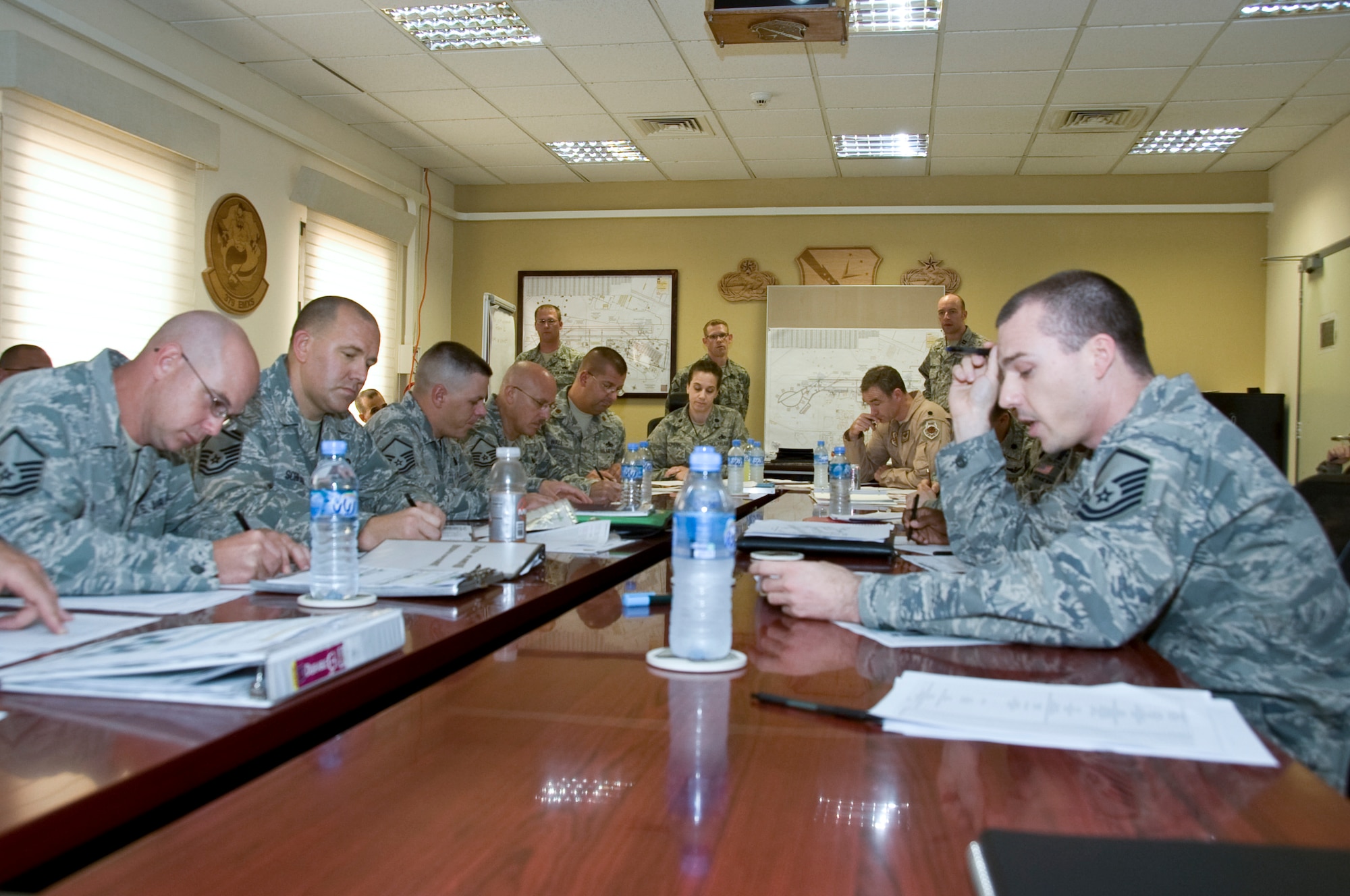 The 379th Expeditionary Maintenance Group hosts a multi-group, table-top meeting with the 379th Expeditionary Operations Group and 379th Expeditionary Mission Support Group members Aug. 17, 2012. The groups met to discuss how each would respond in urgent situations to a variety of aircraft and airfield operations. Readiness is critical throughout the Air Force and particularly important in deployed locations. (U.S. Air Force photo/Senior Airman Bryan Swink) 
