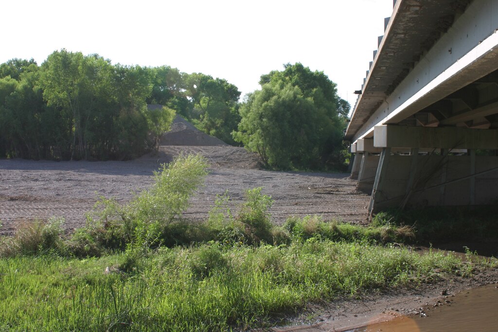 Emergency work by the NMDOT removed 3-5 feet of sediment and debris to increase channel capacity under the Highway 180 Bridge over the Gila River. The sediment is seen piled in the background.  The bridge is approximately 40 miles downstream from the Whitewater-Baldy Fire’s burn area.
