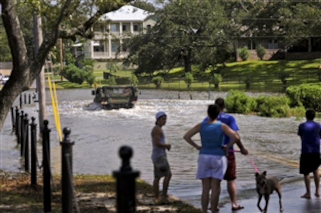 Soldiers travel through flooded waters on Washington Street in Ocean Springs, Miss., Aug. 28, 2012. The soldiers, assigned to 1st Battalion, 204th Air Defense Artillery, are some of the 1,500 Mississippi National Guardsmen responding to Hurricane Isaac.