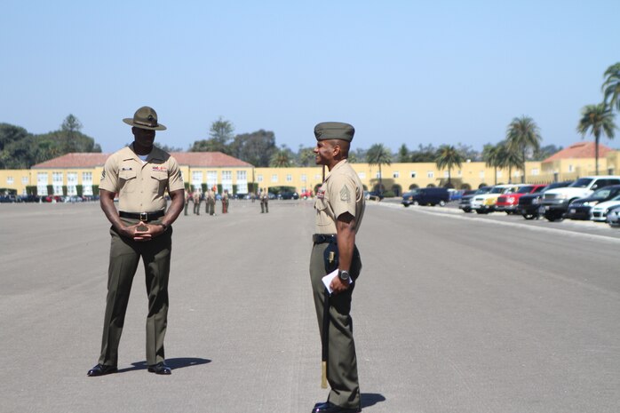 Staff Sgt. James Foster, squad instructor, MCRD San Diego Drill Instructor School, observes as a student from his squad practices drill movements and calls commands aboard the parade deck July 26. DI School squad instructors provide daily mentorship for Marines who undergo 57 training days to become drill instructors and transform civilians into combat-ready Marines.