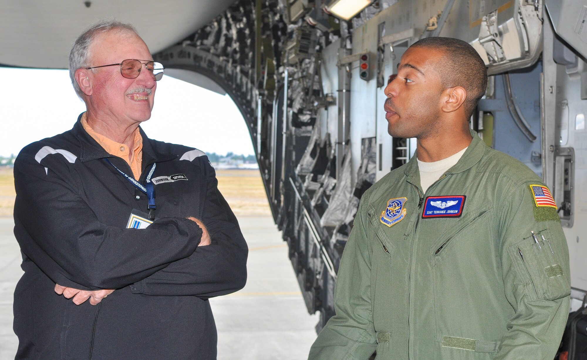 John A. Childress, guest of a Distinguished Flying Cross Medal recipient, speaks with Staff Sgt. Terrance Johnson, 4th Airlift Squadron loadmaster, Aug. 22, 2012, aboard a C-17 Globemaster III aircraft at Joint Base Lewis-McChord, Wash. Members of the Distinguished Flying Cross Society and their guests met with Airmen and got an up-close look at a C-17 aircraft. (U.S. Air Force photo/Staff Sgt. Sean Tobin)