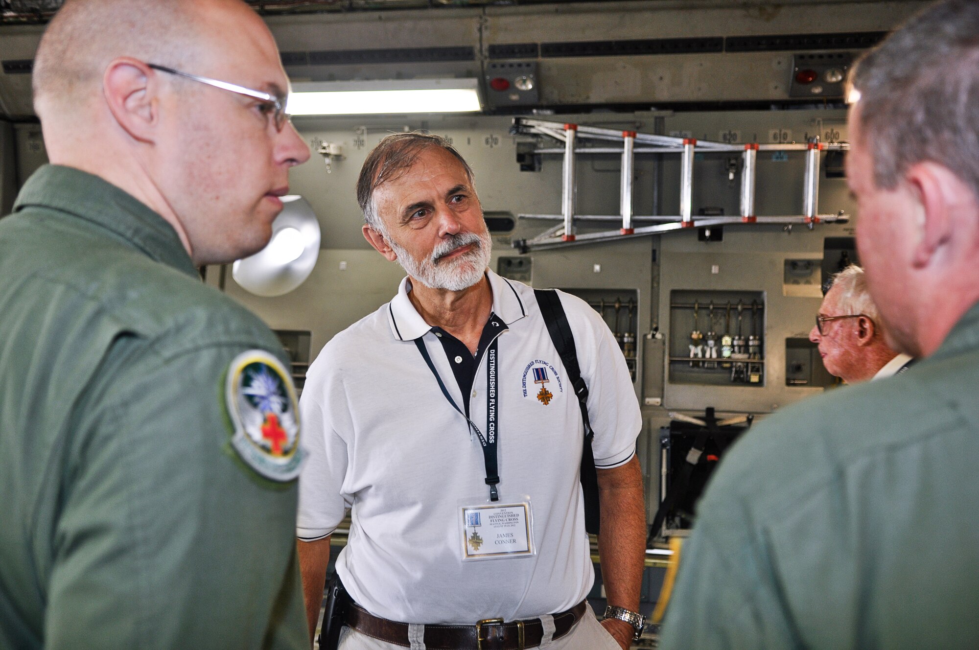 James Conner, Distinguished Flying Cross Medal recipient, speaks with Tech. Sgt. Shawn Clayton (left) and Senior Airman Timothy Keene (right), 446th Aeromedical Evacuation Squadron medical technicians, Aug. 22, 2012, aboard a C-17 Globemaster III aircraft at Joint Base Lewis-McChord, Wash. Members of the Distinguished Flying Cross Society and their guests met with Airman and got an up-close look at a C-17 aircraft. (U.S. Air Force photo/Staff Sgt. Sean Tobin)