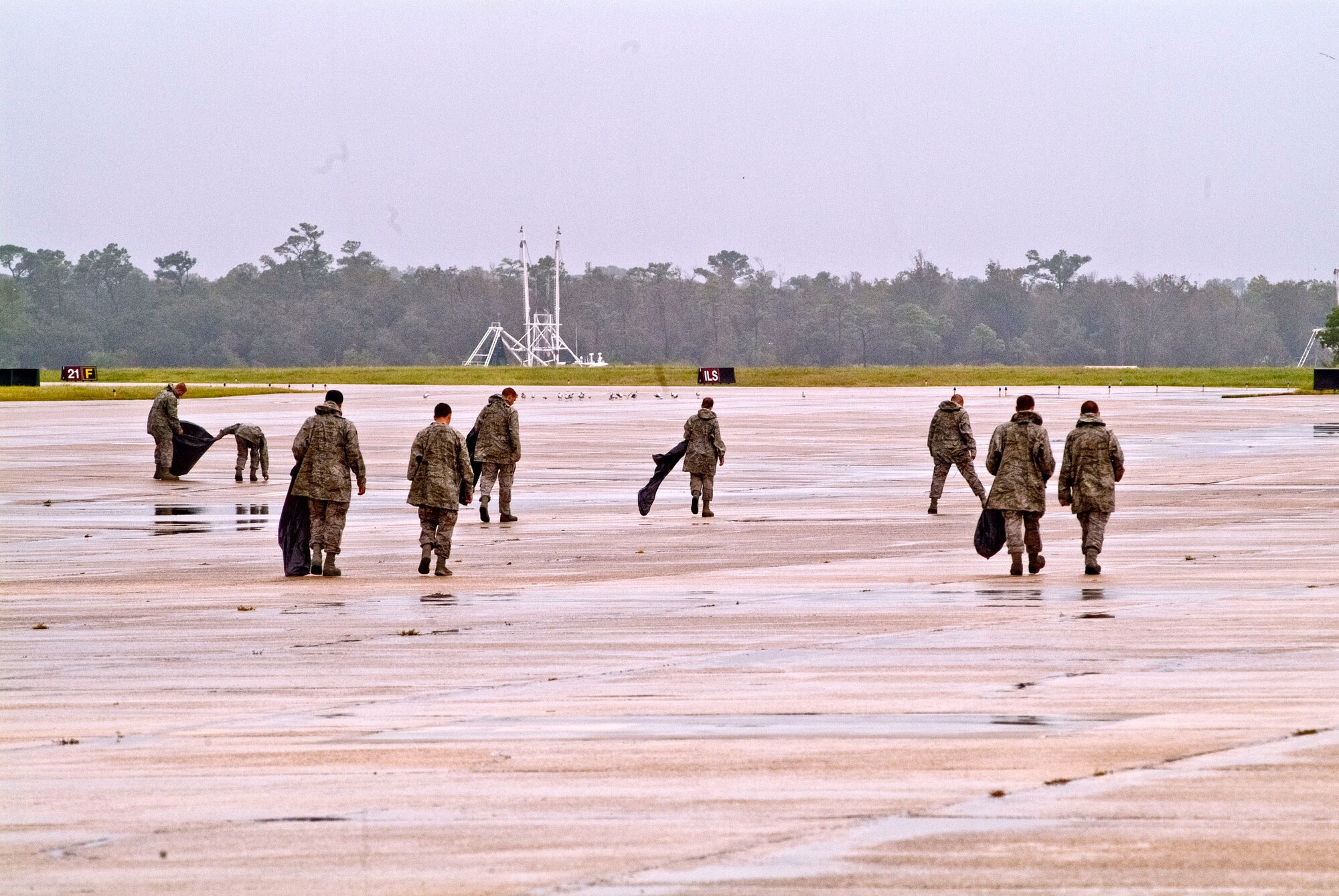 Members of the 334th Training Squadron line up across the flight line to perform a foreign object debris walk Aug. 30, 2012, at Keesler Air Force Base, Miss., during base restoration following landfall of Hurricane Isaac.  The FOD walk was held to clear the flight line of debris that could potentially cause damage to aircraft engines.  In an effort to ensure the safety of Keesler personnel and assets during Hurricane Isaac, the base was closed Aug. 28-29 and reopened Aug. 30 following minimal damage.  (U.S. Air Force photo by Herb Welch)