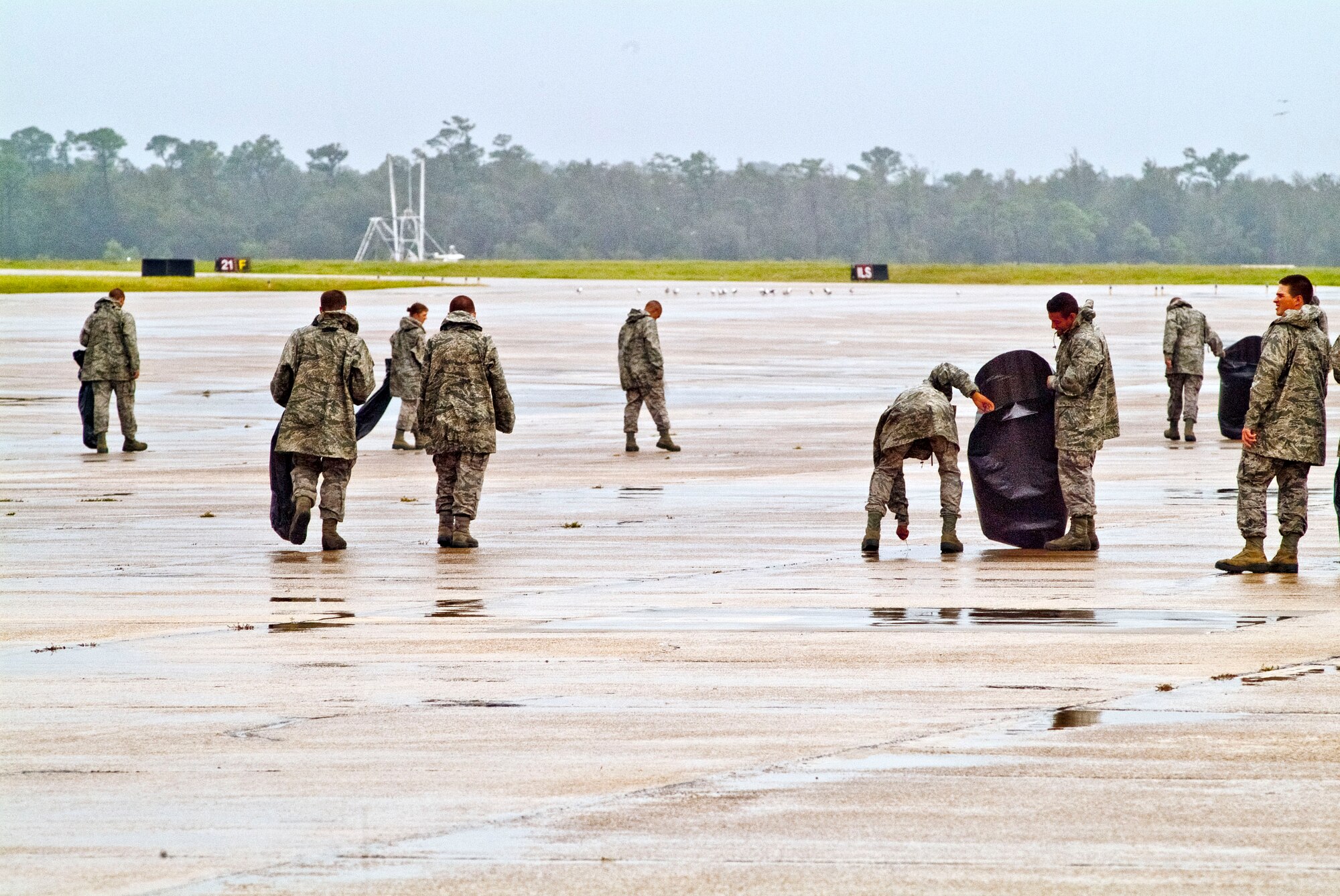 Members of the 334th Training Squadron line up across the flight line to perform a foreign object debris walk Aug. 30, 2012, at Keesler Air Force Base, Miss., during base restoration following landfall of Hurricane Isaac.  The FOD walk was held to clear the flight line of debris that could potentially cause damage to aircraft engines.  In an effort to ensure the safety of Keesler personnel and assets during Hurricane Isaac, the base was closed Aug. 28-29 and reopened Aug. 30 following minimal damage.  (U.S. Air Force photo by Herb Welch)