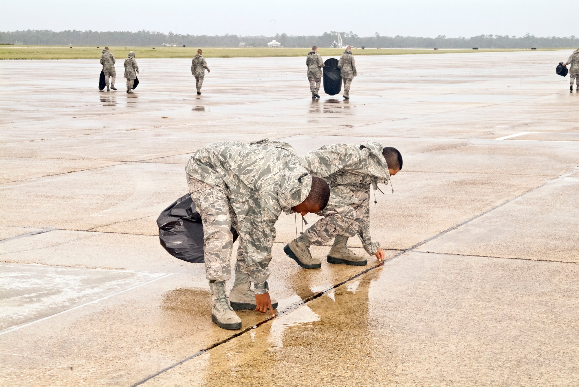 Members of the 334th Training Squadron line up across the flight line to perform a foreign object debris walk Aug. 30, 2012, at Keesler Air Force Base, Miss., during base restoration following landfall of Hurricane Isaac.  The FOD walk was held to clear the flight line of debris that could potentially cause damage to aircraft engines.  In an effort to ensure the safety of Keesler personnel and assets during Hurricane Isaac, the base was closed Aug. 28-29 and reopened Aug. 30 following minimal damage.  (U.S. Air Force photo by Herb Welch)