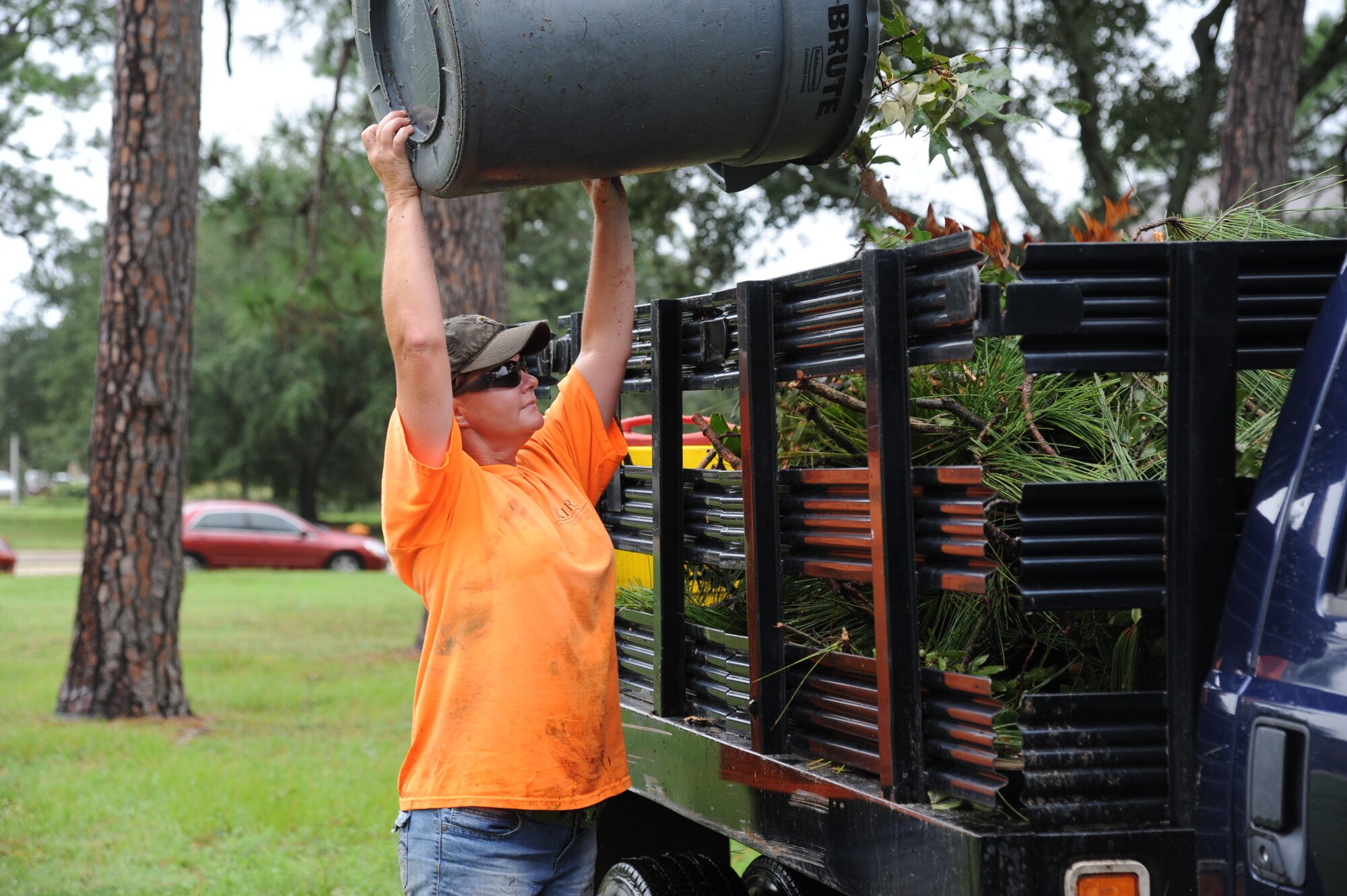 Carmen Gabriel, KIRA Facilities Maintenance & Construction, dumps a can full of debris in the back of a truck, Aug. 30, 2012, at Keesler Air Force Base, Miss., during base restoration following landfall of Hurricane Isaac. In an effort to ensure the safety of Keesler personnel and assets during Hurricane Isaac, the base was closed Aug. 28-29 and reopened Aug. 30 following minimal damage.  (U.S. Air Force photo by Kemberly Groue)