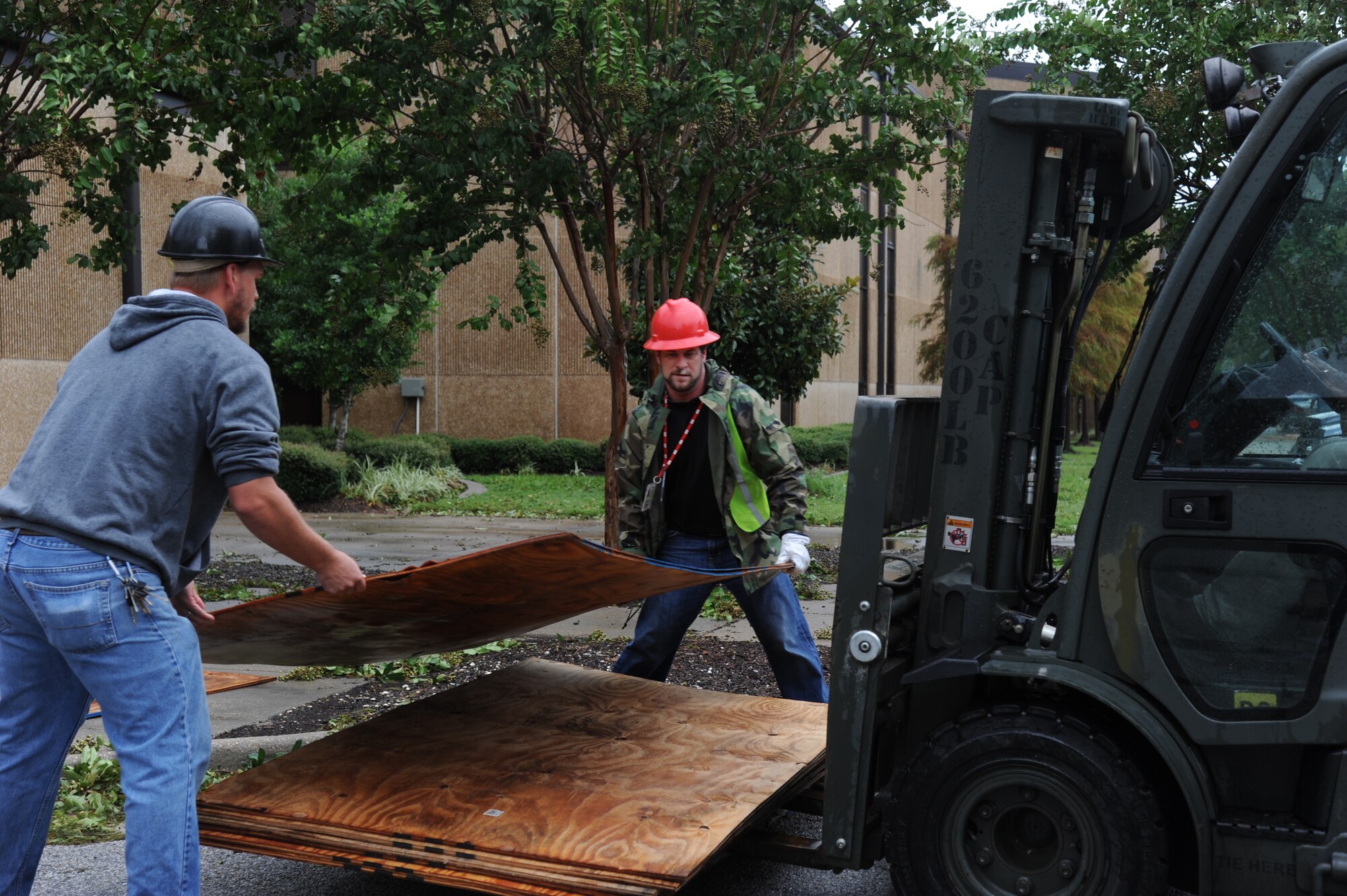 Jeremy Railey and Dennis Fink, CSC, load sheets of plywood on a fork lift after removing the plywood from the windows of Base Operations center Aug. 30, 2012, at Keesler Air Force Base, Miss., during base restoration following landfall of Hurricane Isaac. In an effort to ensure the safety of Keesler personnel and assets during Hurricane Isaac, the base was closed Aug. 28-29 and reopened Aug. 30 following minimal damage.  (U.S. Air Force photo by Kemberly Groue)