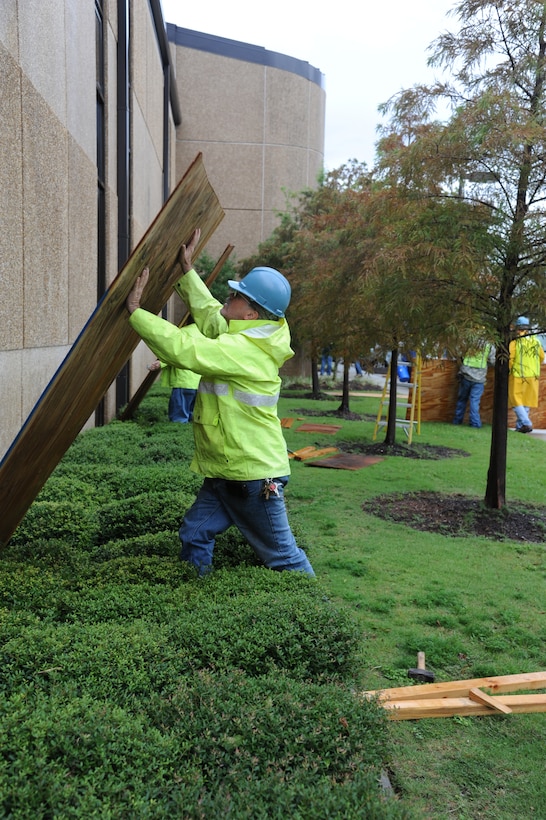 John Akins, CSC, removes boards from the windows of Base Operations center Aug. 30, 2012, at Keesler Air Force Base, Miss., during base restoration following landfall of Hurricane Isaac. In an effort to ensure the safety of Keesler personnel and assets during Hurricane Isaac, the base was closed Aug. 28-29 and reopened Aug. 30 following minimal damage.  (U.S. Air Force photo by Kemberly Groue)