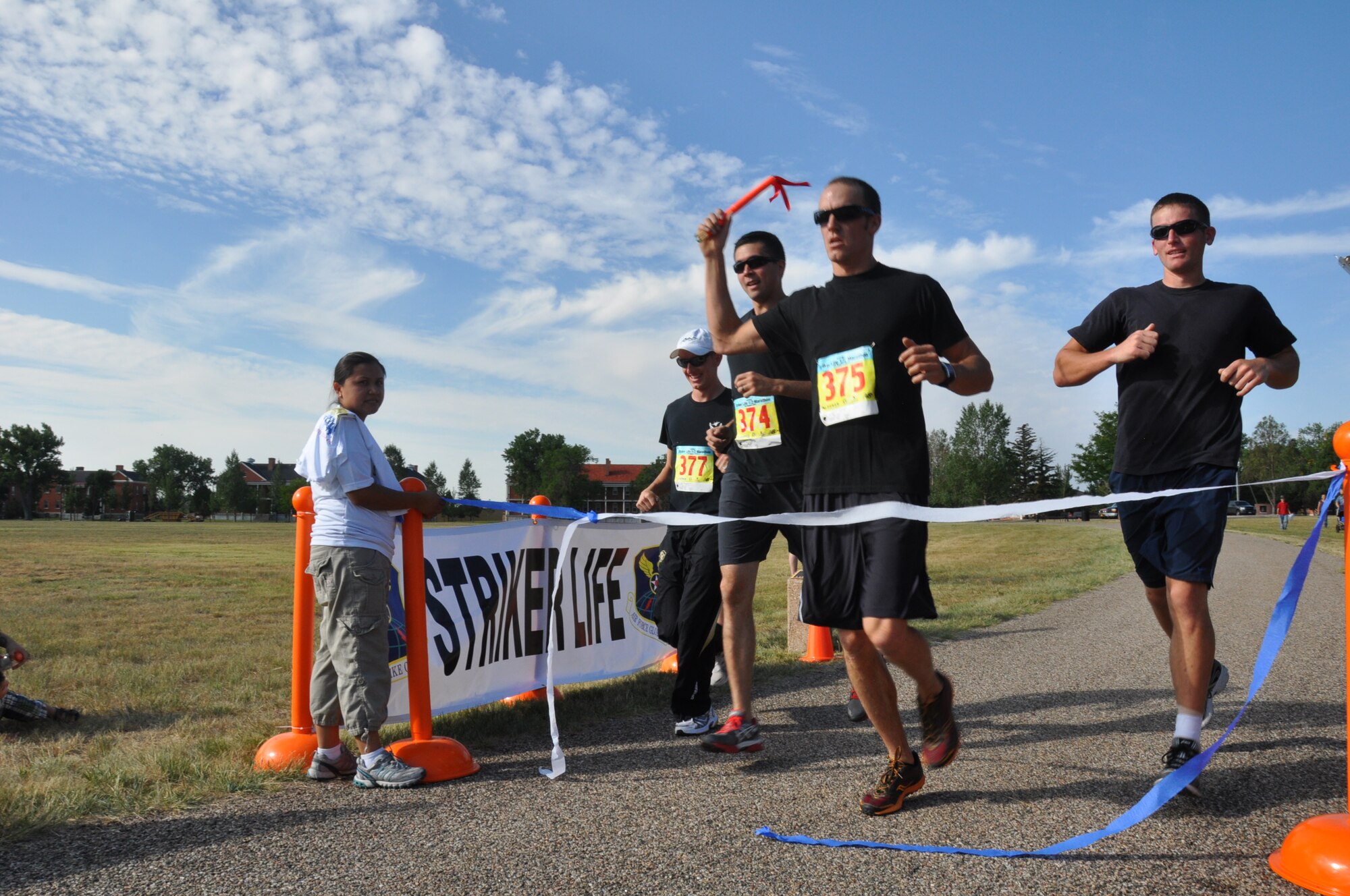 Capt. Peter Dobbins, 1st Lt. Austin Winner, 1st Lt. Jeffery Rees, and 2nd Lt. Alex Foos, all from the 320th Missile Squadron, cross the line as a team, to finish the Striker Life Half Marathon at F. E. Warren Air Force Base, Wyo., Aug. 24. The four competed in the relay event, representing the 90th Operations Group and finishing with a time of 1:35.49. (U.S. Air Force photo by Senior Airman Dan Gage)