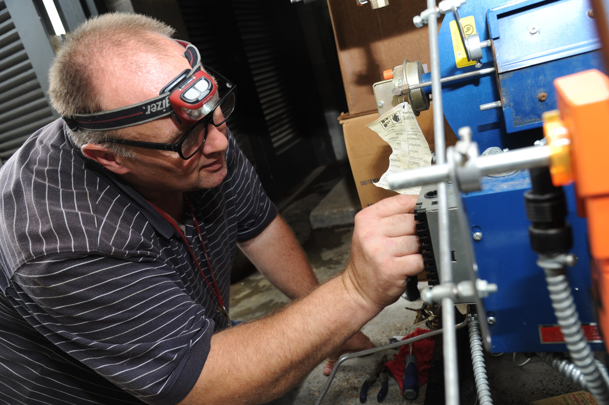 Randy Stoker, CSC control technician, replaces a water-damaged burner control to a steam boiler at the Live Oak Dining Facility Aug. 30, 2012, at Keesler Air Force Base, Miss., during base restoration following landfall of Hurricane Isaac.  In an effort to ensure the safety of Keesler personnel and assets during Hurricane Isaac, the base was closed Aug. 28-29 and reopened Aug. 30 following minimal damage.  (U.S. Air Force photo by Kemberly Groue) 