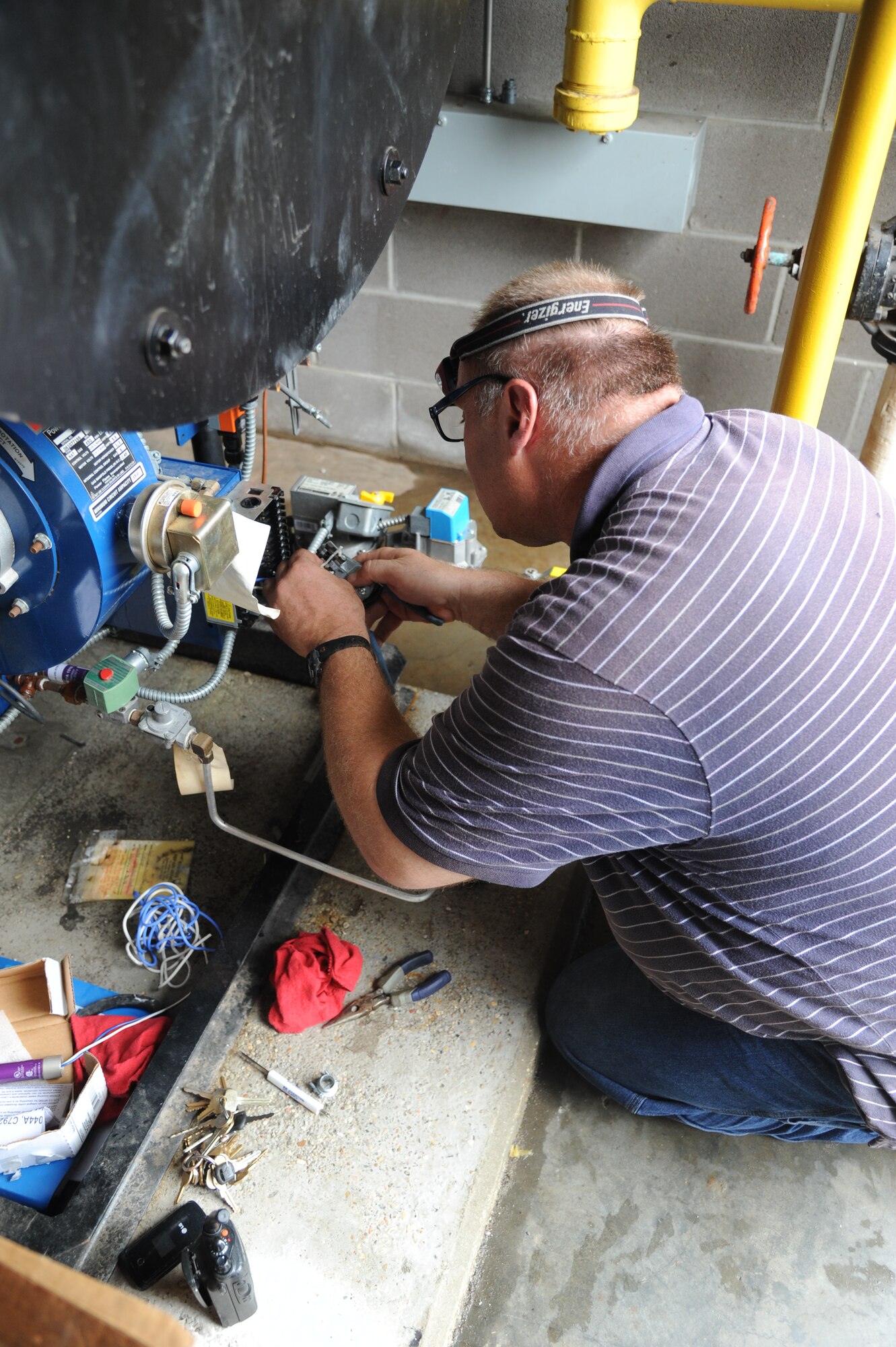 Randy Stoker, CSC control technician, replaces a water-damaged burner control to a steam boiler at the Live Oak Dining Facility Aug. 30, 2012, at Keesler Air Force Base, Miss., during base restoration following landfall of Hurricane Isaac.  In an effort to ensure the safety of Keesler personnel and assets during Hurricane Isaac, the base was closed Aug. 28-29 and reopened Aug. 30 following minimal damage.  (U.S. Air Force photo by Kemberly Groue) 