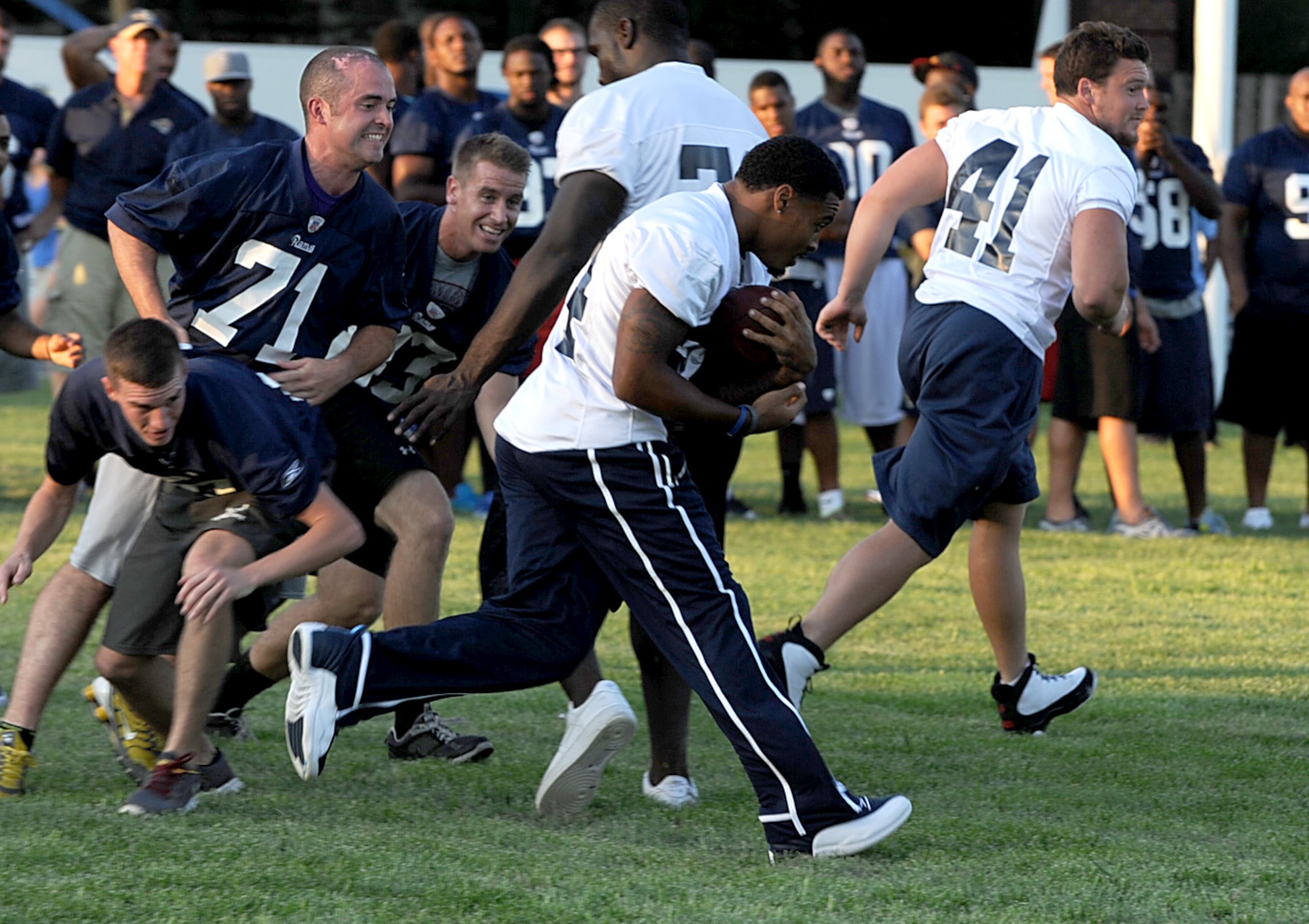 St. Louis Rams running back Isaiah Pead follows his blocks past Team Scott defensive members during a walk through practice Aug. 29 at Scott Air Force Base, Ill. Team Scott members were given plays by Rams coaching staff, similar to plays the Rams will see on game day. (U.S. Air Force photo/ Staff Sgt. Brian J. Valencia)