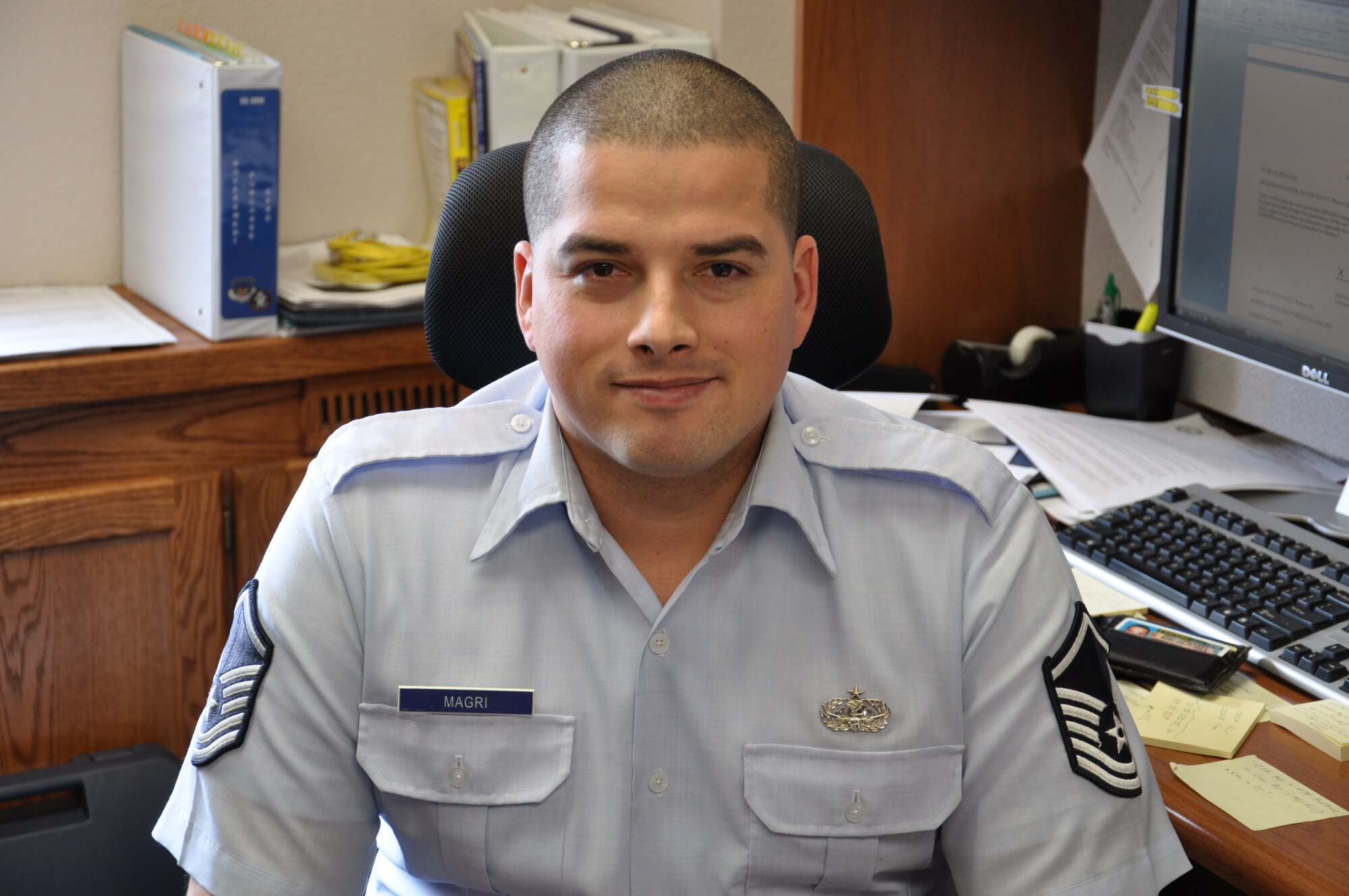 Master Sgt. Fernando Magri, 90th Missile Wing command section superintendent, poses for a photograph while sitting at his desk. Magri recently returned from a 150-day deployment to Bogotá, Colombia, where he aided in U.S. Southern Command’s mission. (U.S. Air Force photo by Senior Airman Mike Tryon)