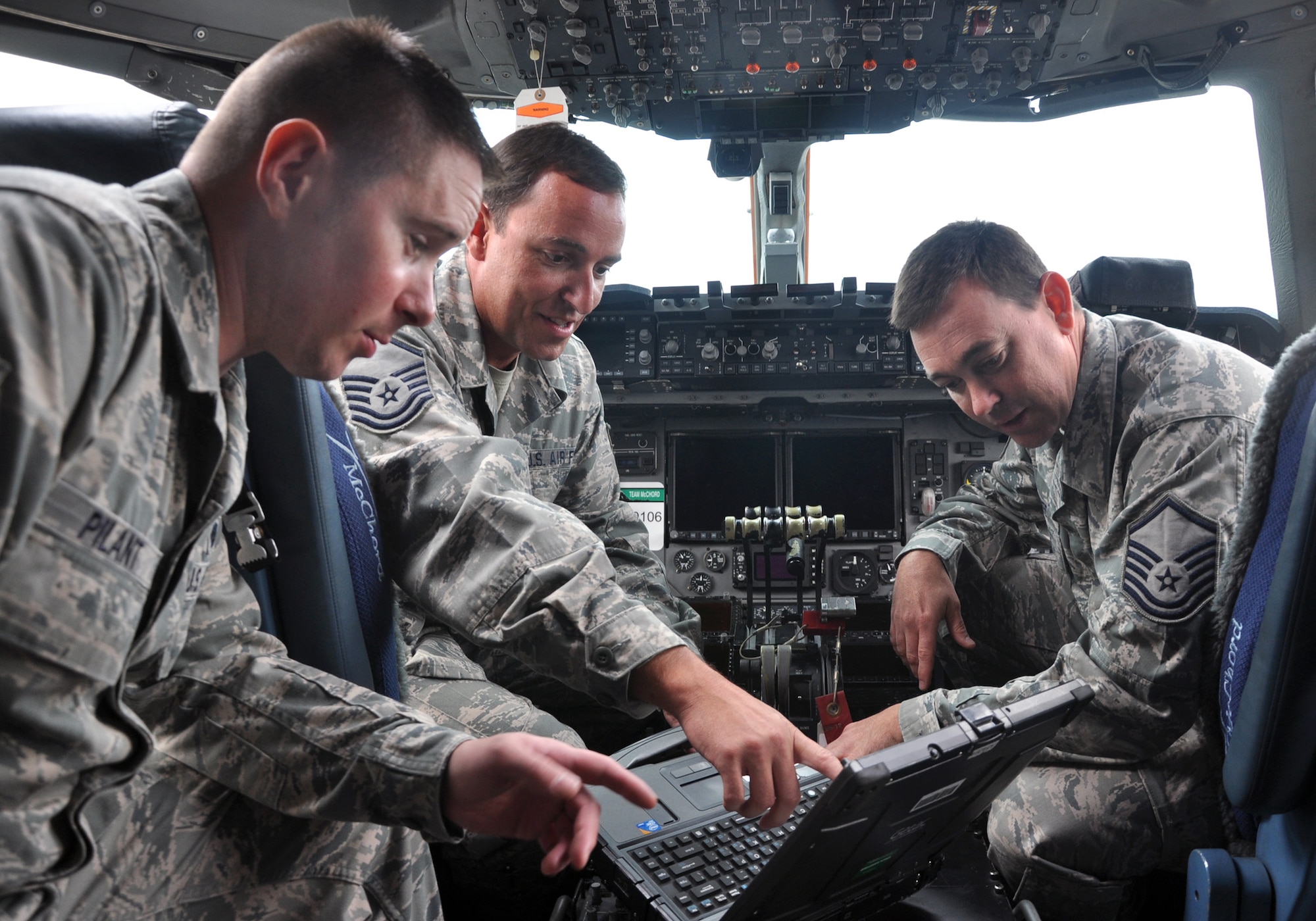 MCCHORD FIELD, Wash. – (Left to right) Senior Airman Jerrod Pilant, 446th Aircraft Maintenance Squadron crew chief here, with crew chiefs Master Sgt. Jesse Spainhour and Master Sgt. Todd Jones, 164th Aircraft Maintenance Squadron, Tennessee Air National Guard, check radio frequencies on the flight deck of a C-17 Globemaster III, Aug. 30.  Jones is leading a group of crew chiefs from the Tennessee Air Guard who are training with Reservists from the 446th AMXS gaining proficiency and certification for C-17 aircraft systems.  (U.S. Air Force photo by Tech. Sgt. Elizabeth Moody)