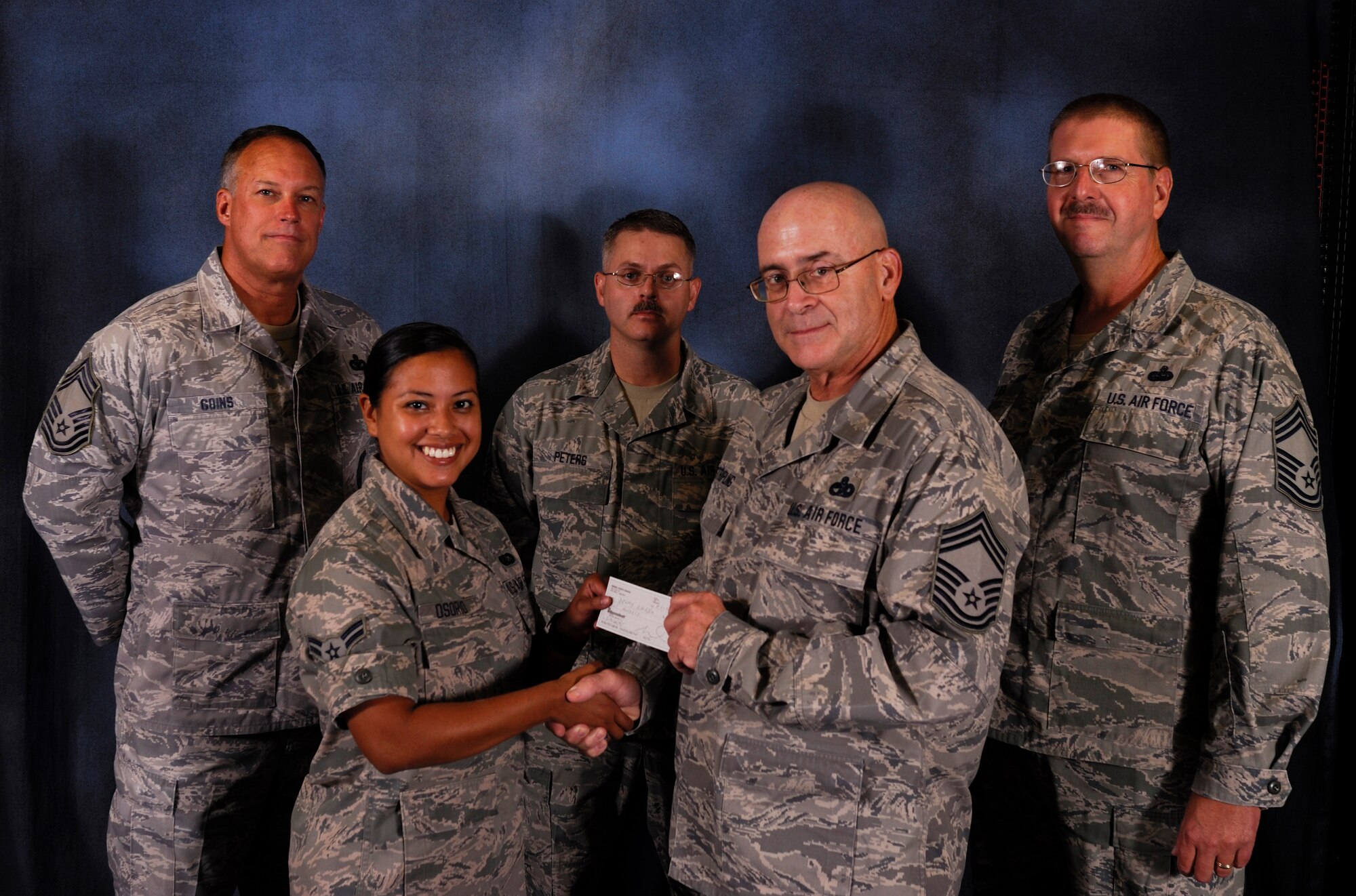 Airman 1st Class Delmy Carolina Osorio, a member of the 188th Force Support Squadron, is presented a check by Chief Master Sgt. Hank Stripling at the 188th Fighter Wing Aug. 5, 2012, as Chief Master Sgt. Archie Goins, left, Senior Master Sgt. Bryan Peters, middle, and Chief Master Sgt. James Elder look on. Osorio was awarded a $500 scholarship by the 188th Fighter Wing’s Chiefs Council. (National Guard photo by Airman Cody Martin/188th Fighter Wing Public Affairs)