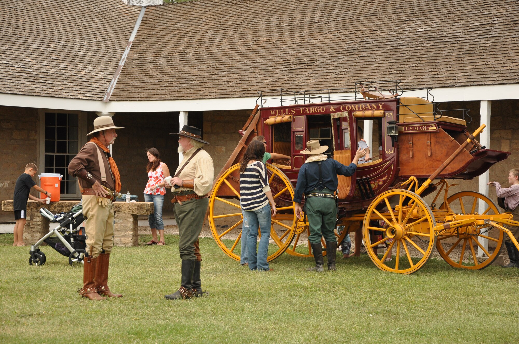 GOODFELLOW AIR FORCE BASE, Texas-- Cowboy Company volunteers’ help children enjoy “riding” the stagecoach during the Blue Star Museum Program event Aug. 25 at the Fort Concho Historic Landmark. Military families were encouraged to tour the museum of the restored Army fort, active 1867 to 1869,  while enjoying the free, fun festivities and food. (U.S. Air Force photo/ Airman 1st Class Erica Flores)
