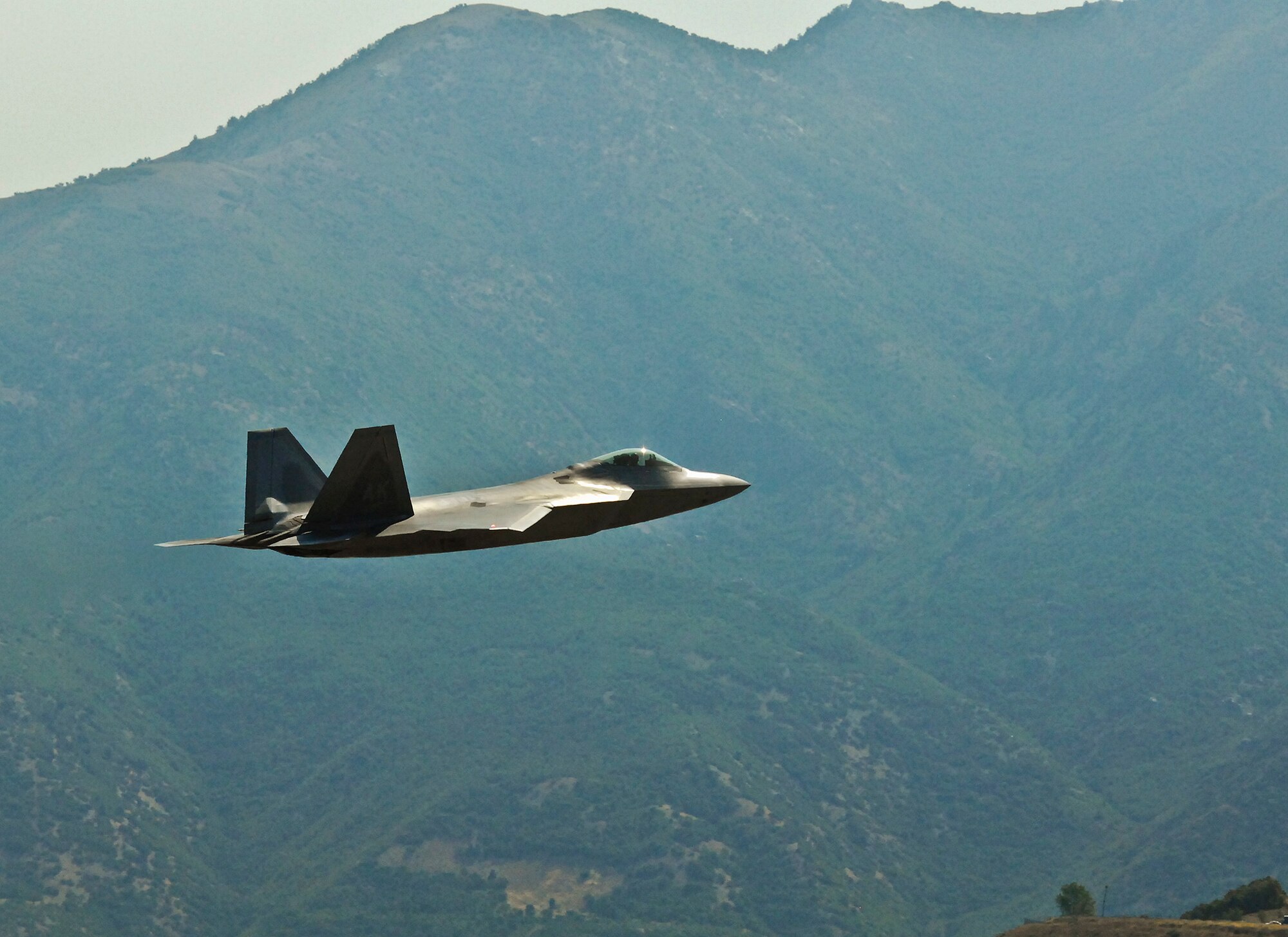 An F-22 Raptor from Elmendorf Air Force Base, Alaska, flies through a mountainous area at Hill Air Force Base, Utah during a Combat Hammer mission. The Combat Hammer missions were part of an annual month-long weapons system evaluation program held at the base by the 53rd Weapons Evaluation Group. The group is responsible for air-to-ground and air-to-air weapons evaluation for the Air Force.  The air-to-ground unit, known as Combat Hammer, is managed by the 86th Fighter Weapons Squadron, located at Eglin.  The air-to-air unit, known as Combat Archer, is managed by the 83rd Fighter Weapons Squadron, located at Tyndall AFB, Fla. (Courtesy photo)
