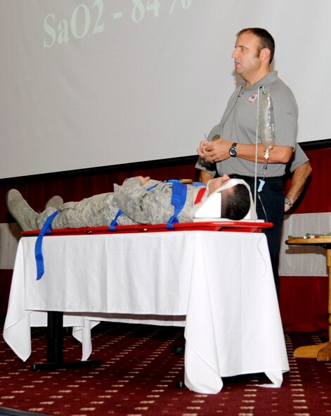 Airman Dylan Fox, 2nd Maintenance Squadron, lies on a stretcher in a Street Smart demonstration given by Patrick Kelly, City of Orlando firefighter and paramedic, at Hoban Hall on Barksdale Air Force Base, La., Aug. 30. Fox was called to the stage to serve as an example of what kind of trauma occurs when a person is involved in a vehicular mishap. (U.S. Air Force photo/Airman 1st Class Andrew Moua)(RELEASED)