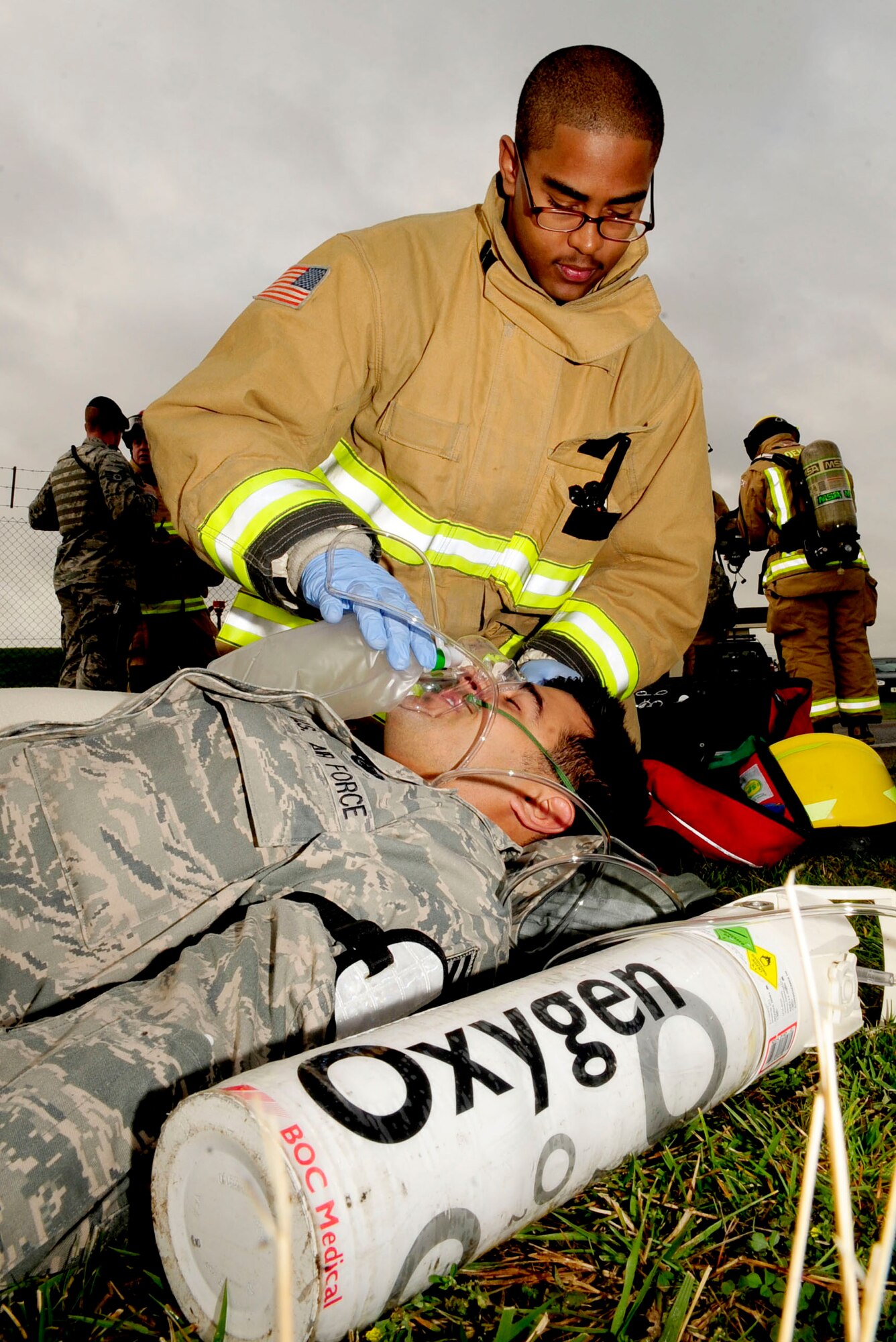 RAF MILDENHALL, England – Airman 1st Class Theodore Willis, 100th Civil Engineer Squadron firefighter, gives Senior Airman Andrew Leal, 100th Logistics Readiness Squadron fuels technician, oxygen after a simulated fuel spill during a major accident response exercise Aug. 30, 2012, at RAF Mildenhall. Leal received oxygen after he simulated collapsing due to the fumes from the simulated fuel spill. (U.S. Air Force photo/Senior Airman Ethan Morgan)