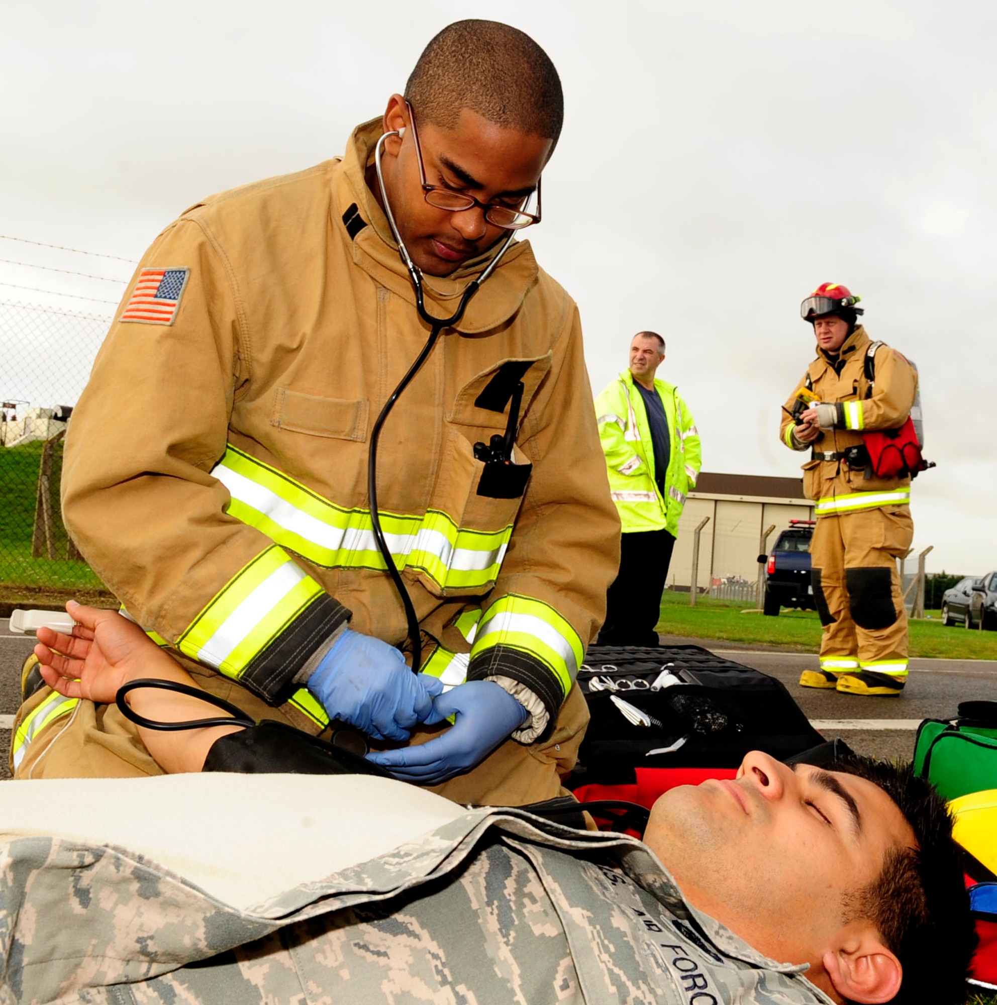 RAF MILDENHALL, England – Airman 1st Class Theodore Willis, 100th Civil Engineer Squadron firefighter, takes Senior Airman Andrew Leal’s, 100th Logistics Readiness Squadron fuels technician, vitals during a major accident response exercise Aug. 30, 2012, at RAF Mildenhall. Willis was one of the first responders who performed simulated treatment on Leal after he feigned collapsing due to the fumes from the simulated fuel spill. (U.S. Air Force photo/Senior Airman Ethan Morgan)